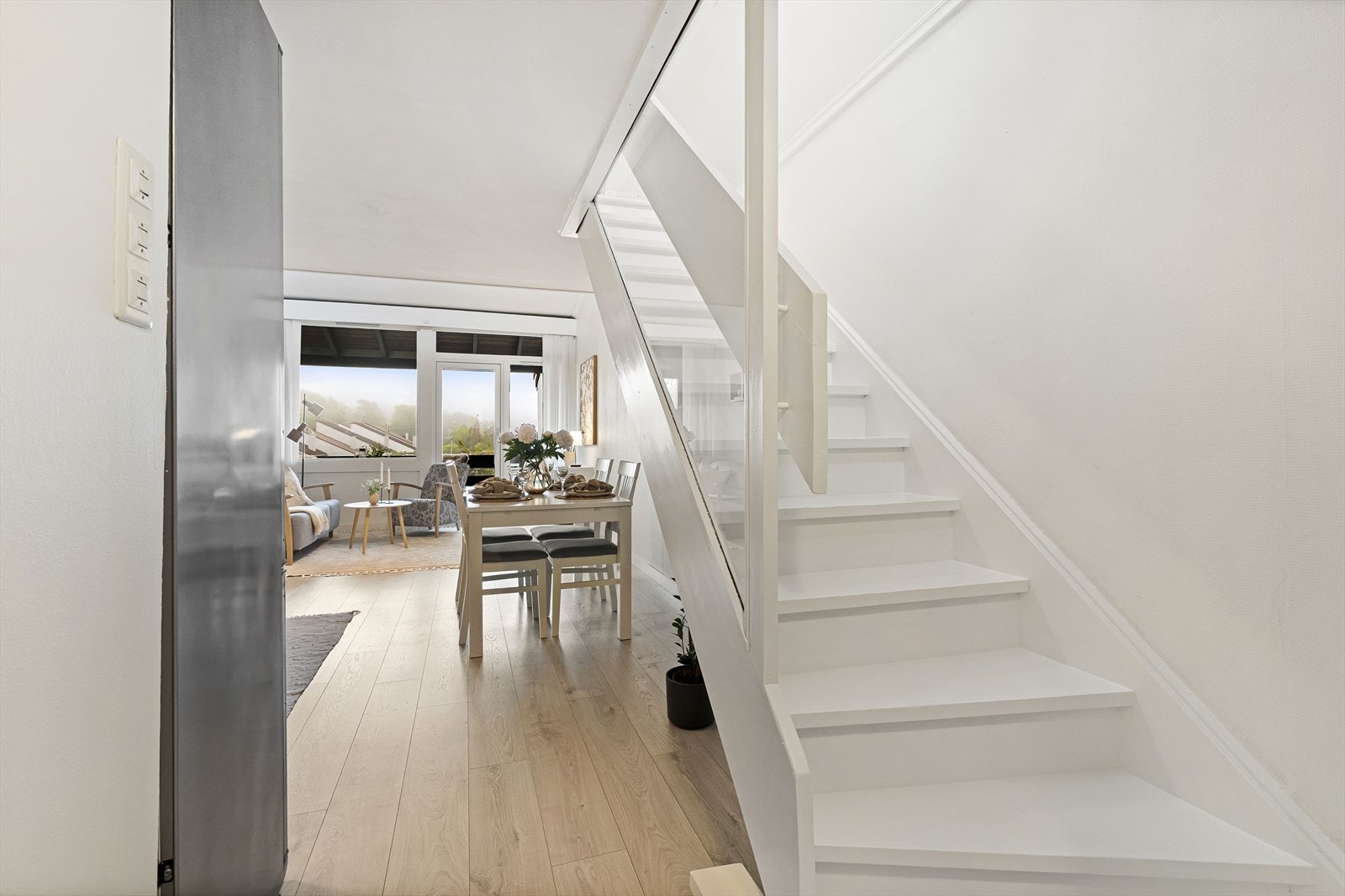 Den hvitmalte tretrappen forbinder leilighetens to plan. Galleribilde