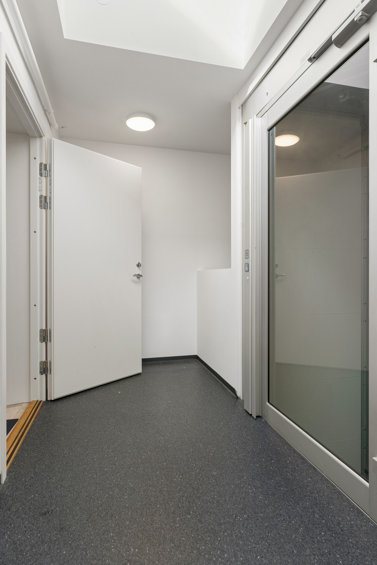 Leilighetsbygget har heis i form av løfteplattform like ved døren til leiligheten. Galleribilde
