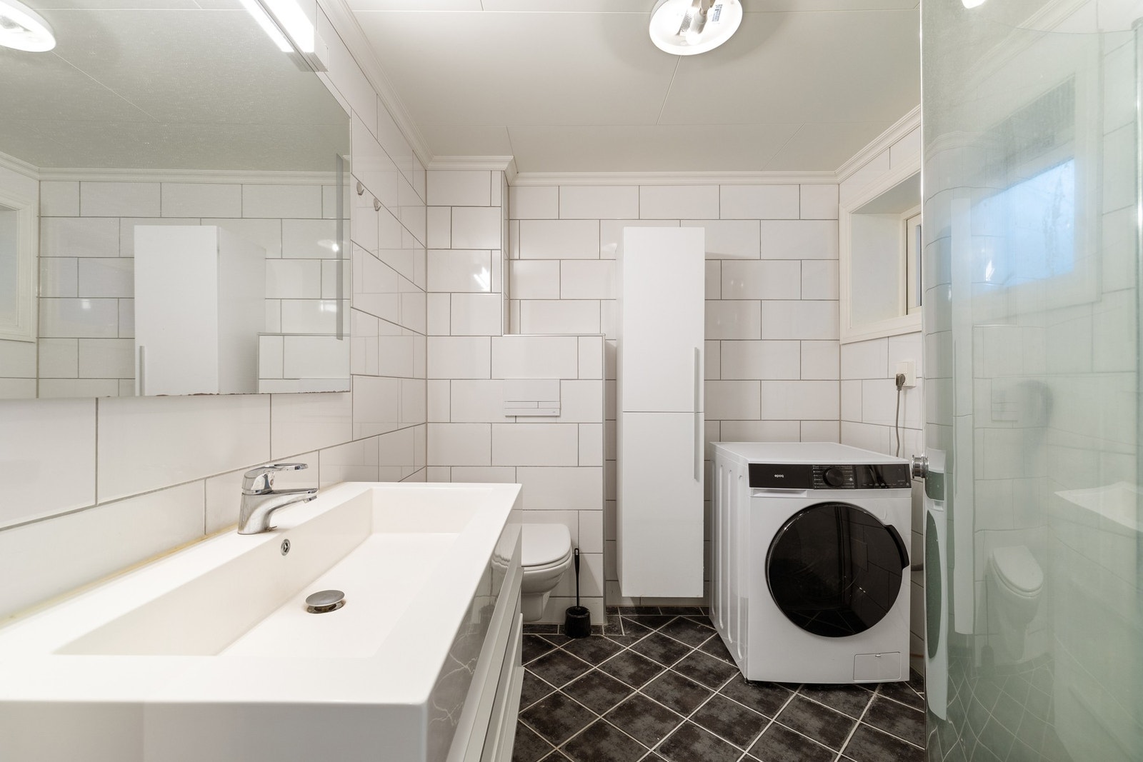 Pent fliselagt bad med plass til vaskemaskin Galleribilde