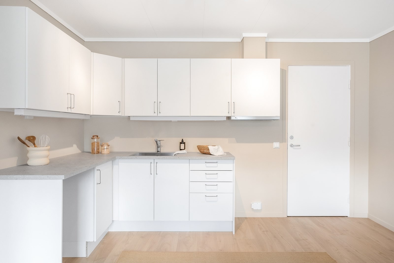 Kjøkkeninnredning med slette fronter, oppgradert med ny laminatbenkeplate og nye håndtak. Galleribilde