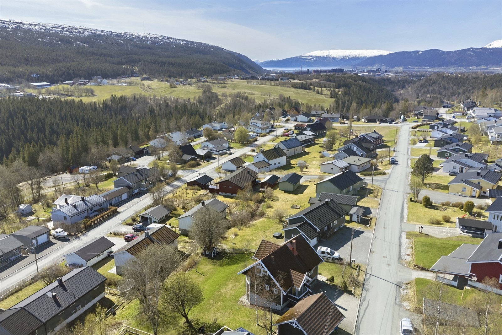 Her dronebilde fra nabohuset og ned mot Mo i Rana. Barnevennlig beliggenhet. Galleribilde