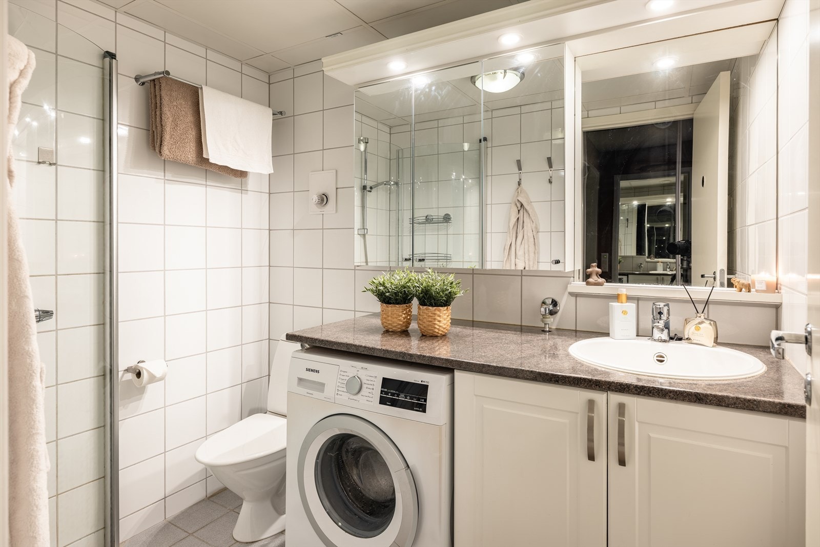 Flislagt bad på 3,5m². Her får du varme i gulv, opplegg for vaskemaskin, dusj med innfellbare dører og godt med oppbevaringsplass i skap. Galleribilde