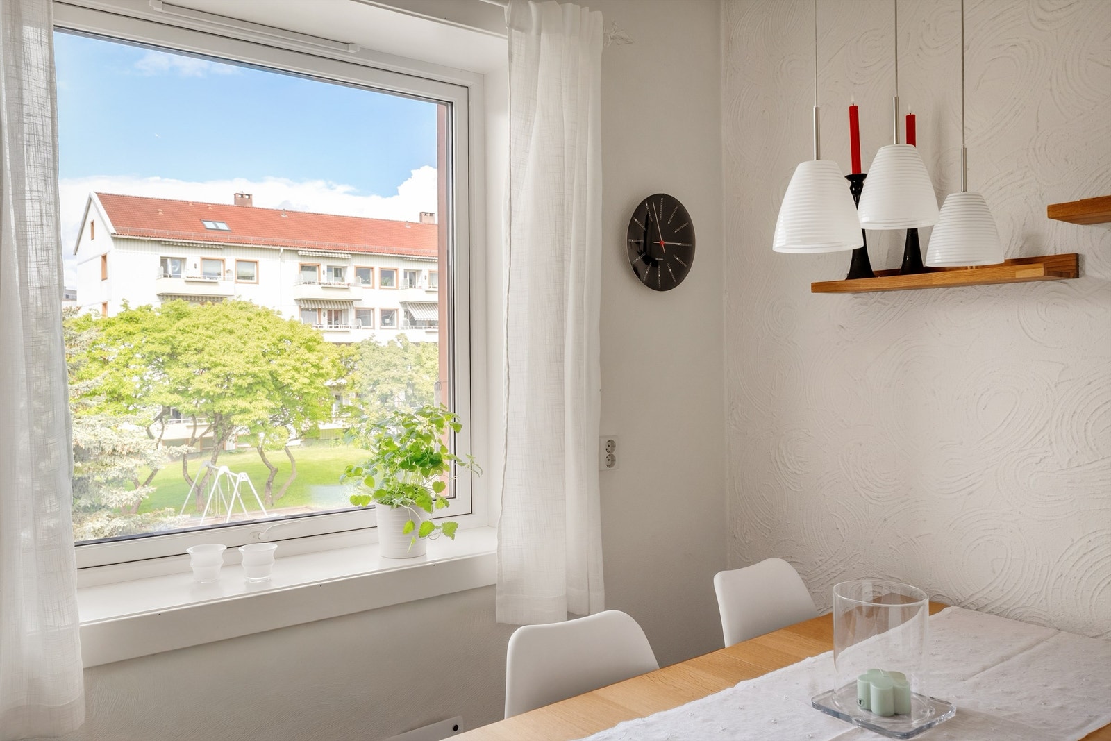 Fra spiseplassen på kjøkkenet ser man ut mot de grønne fellesområdene. Galleribilde