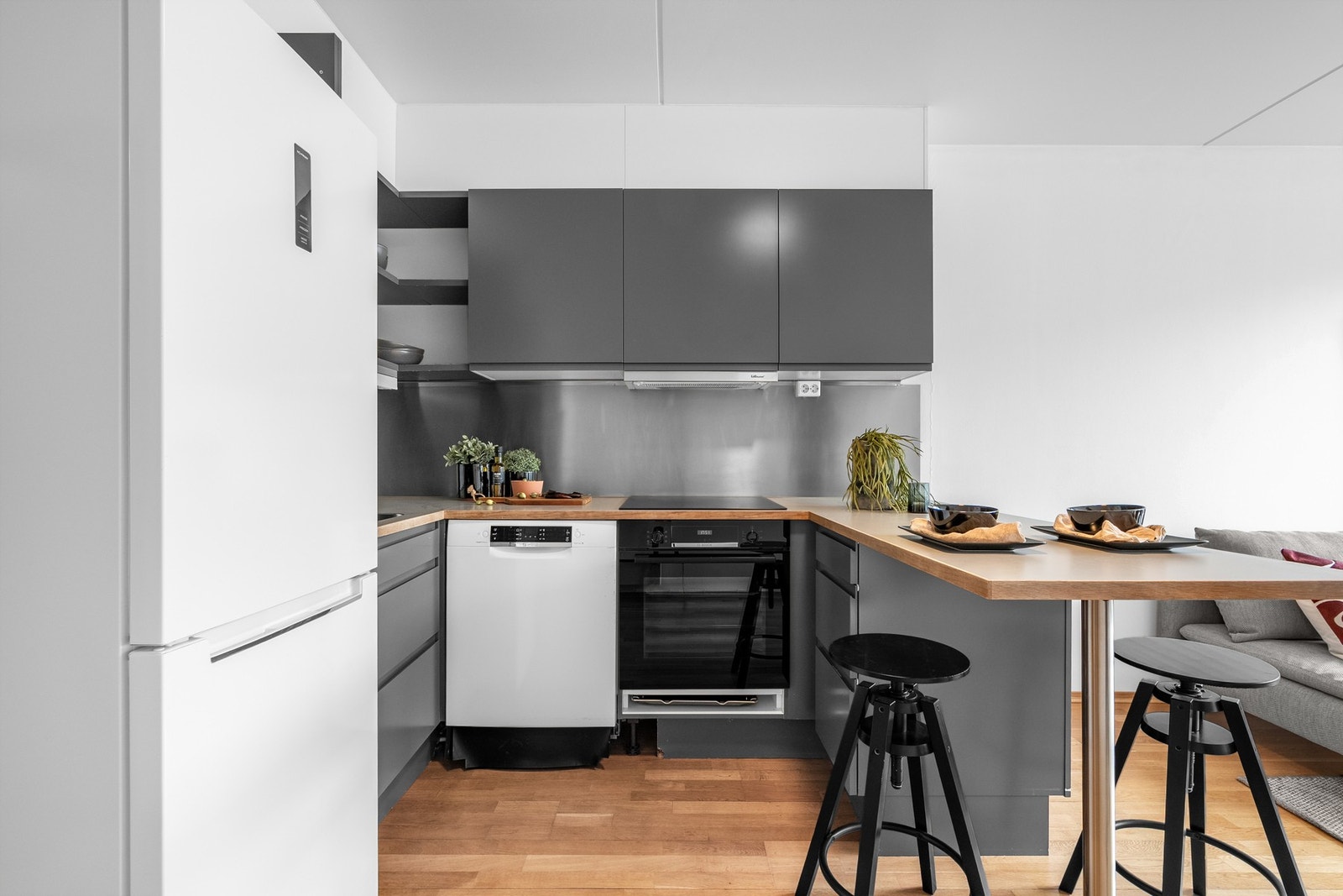 Innredningen har grå glatte fronter og laminert benkeplate med nedfelt oppvaskkum. Praktisk med plater i benkeryggen og belysning under overskapene. Galleribilde