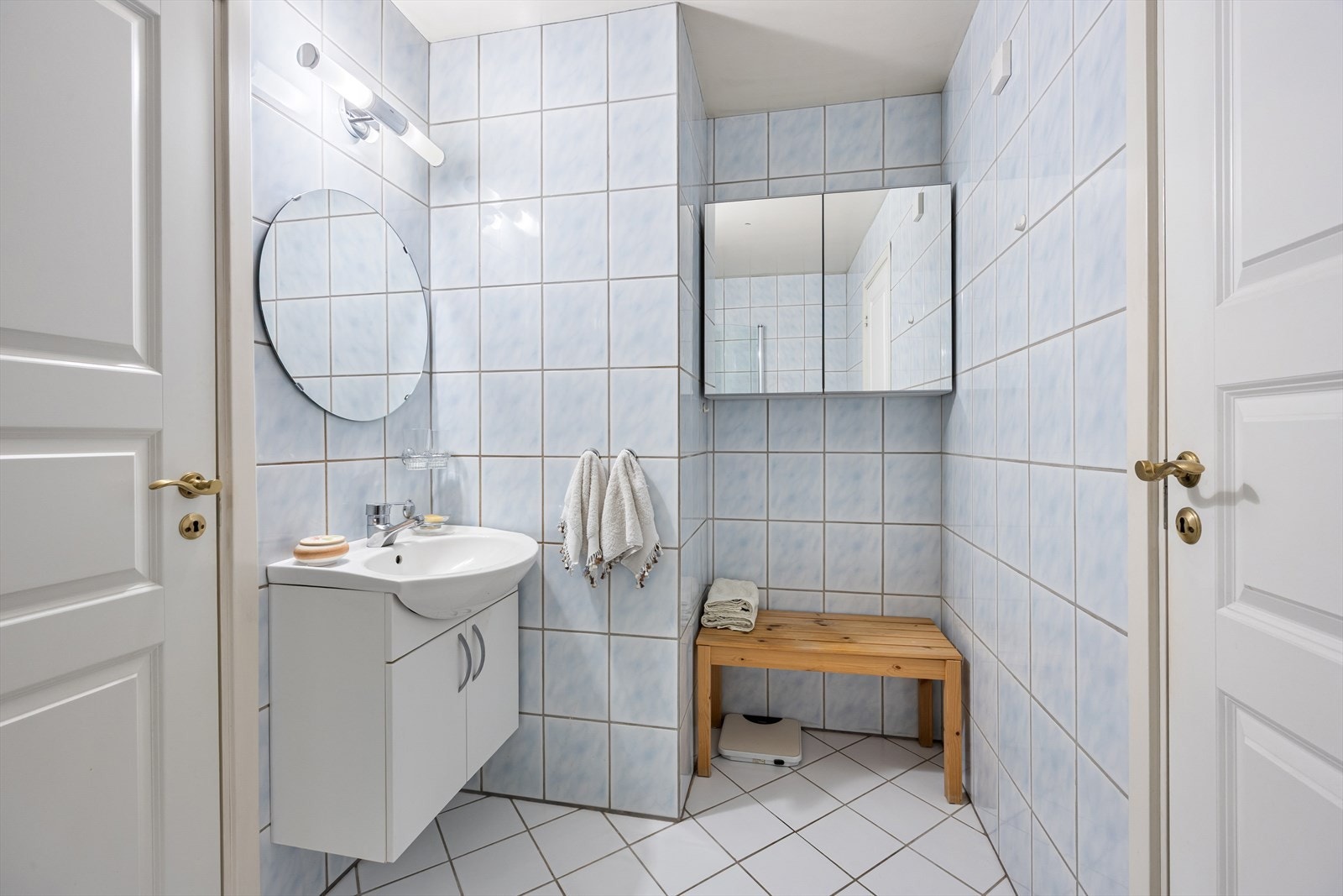 Badet har flislagte vegger, varmekabler i gulvet og servant med underskap. Galleribilde