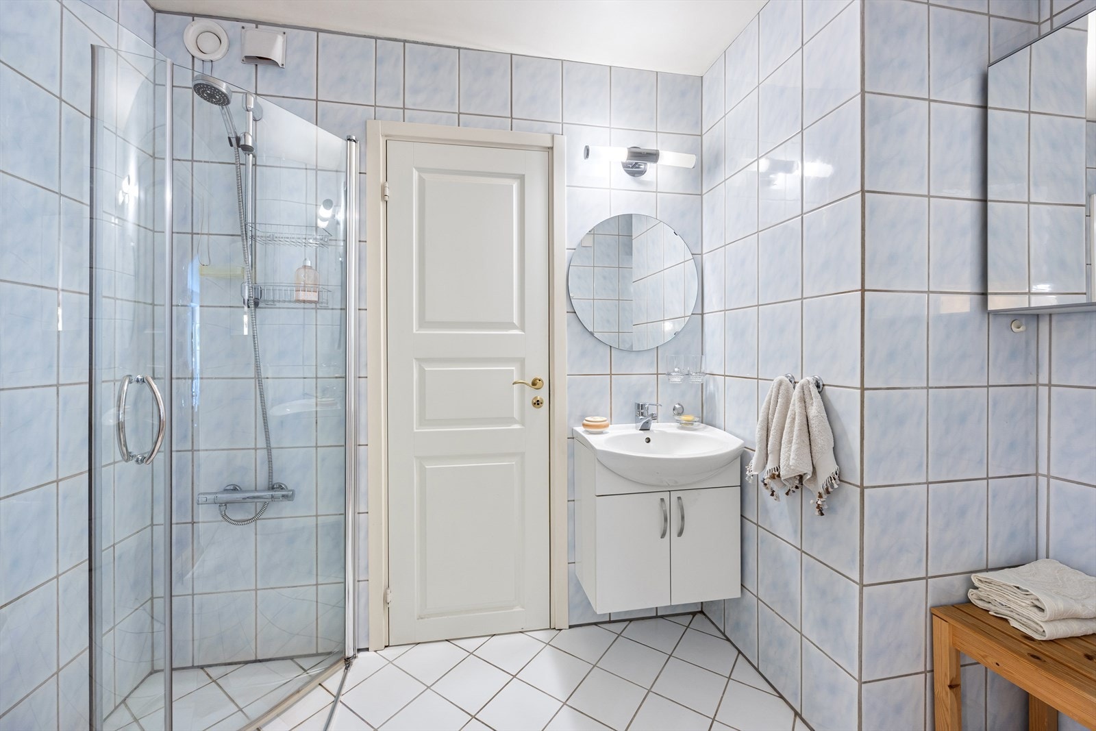 Badet har dusjhjørne med svingbare glassdører, en praktisk løsning med tilknytning til vaskerommet. Galleribilde