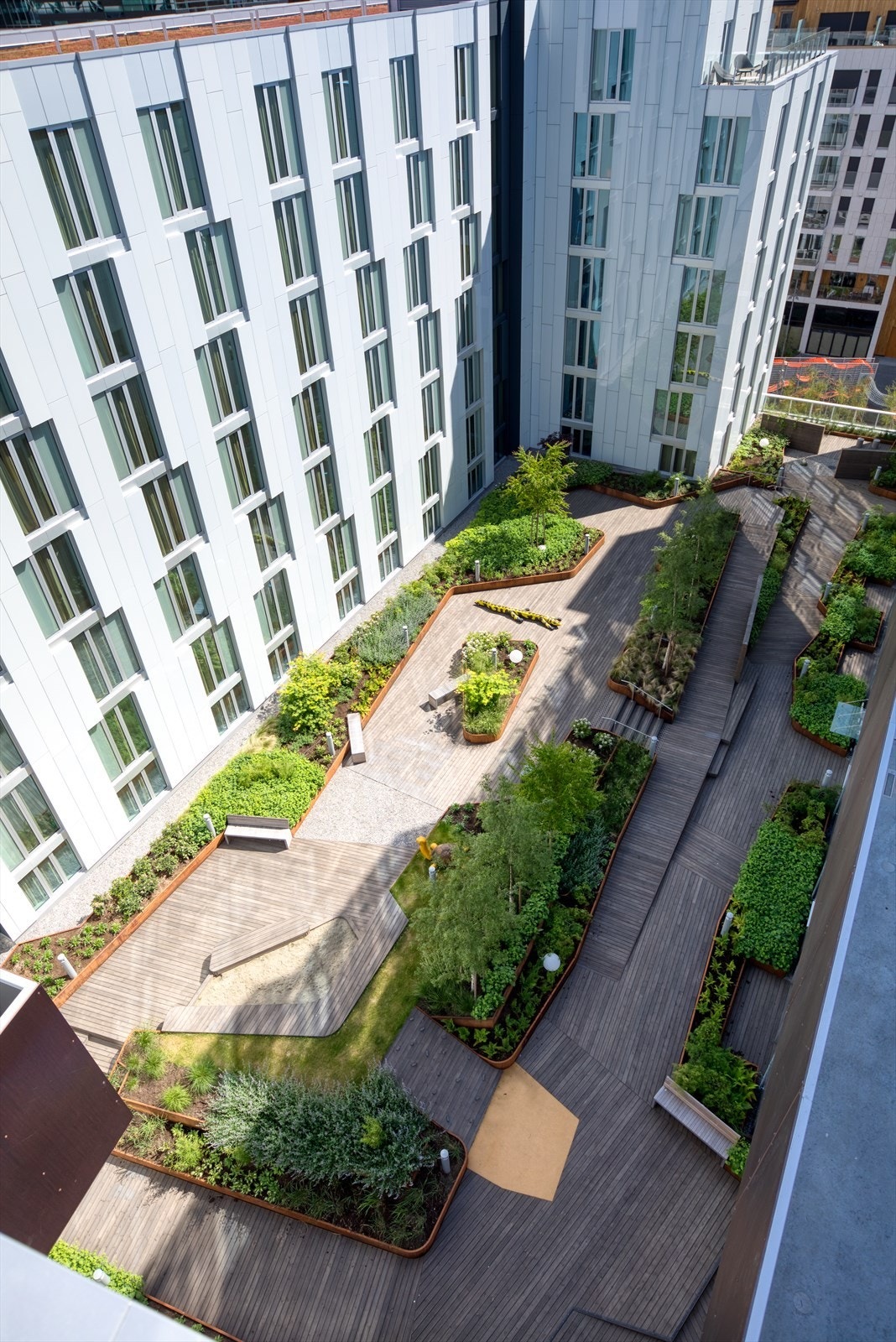 Pent opparbeidet gårdsrom i 3. etasje med beplantning og sitteplasser. Galleribilde