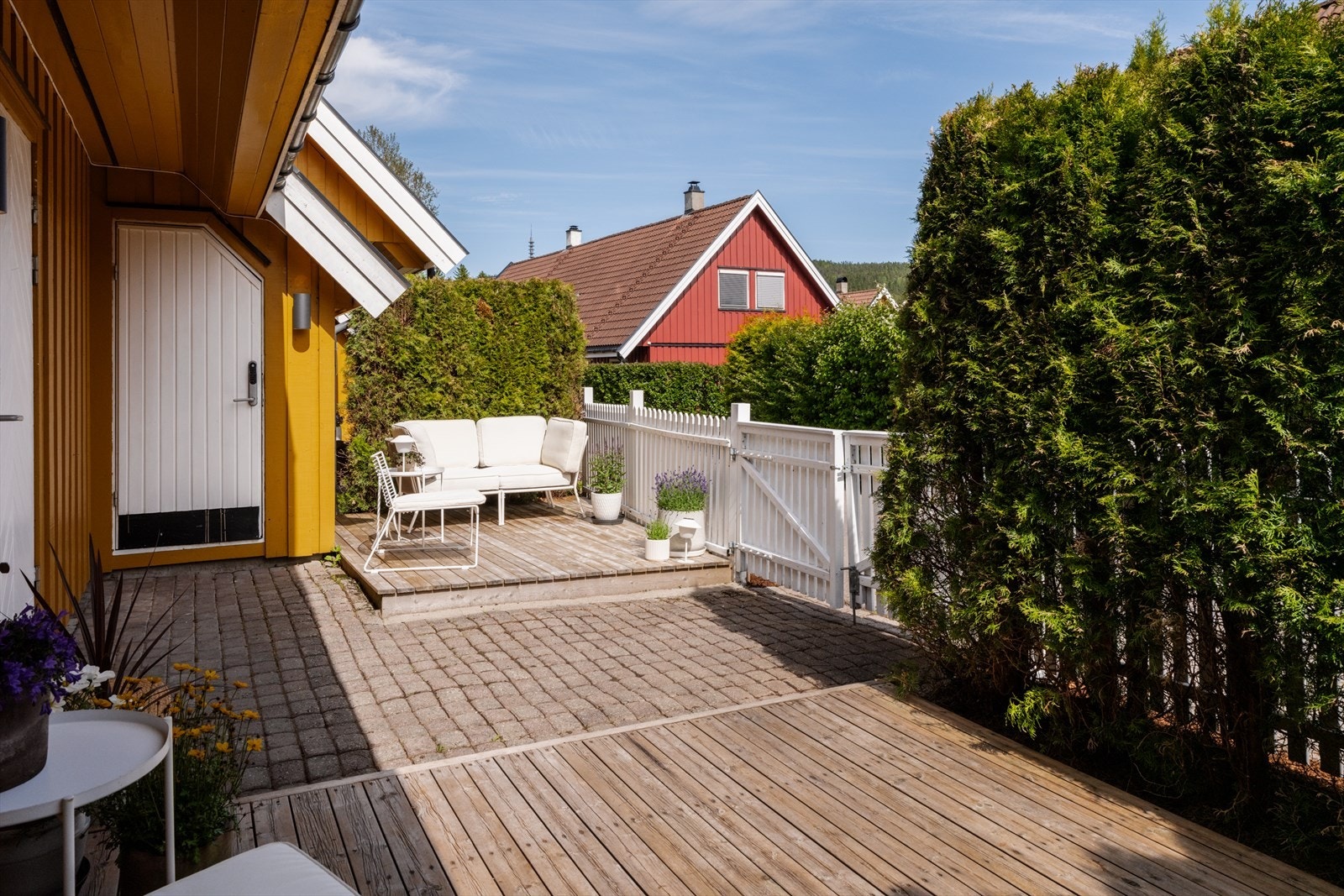 På fremsiden av huset har man også et fint uteareal som kan benyttes med to plattinger på hver sin side. Platting med innredet sittegruppe ble bygget i 2024. Galleribilde