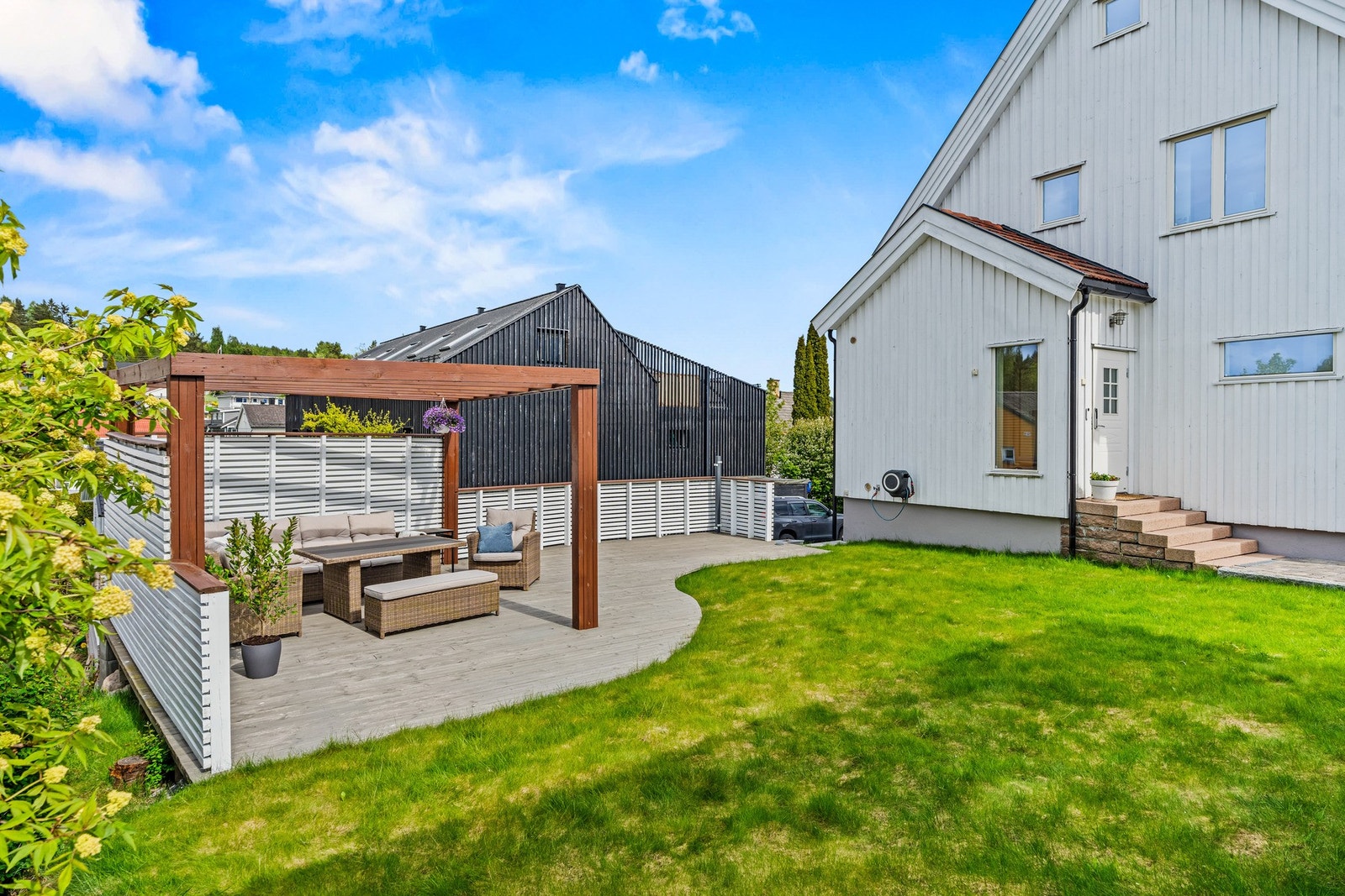Pent opparbeidet tomt med kombinasjon av plen, gårdsplass og terrasse. Galleribilde