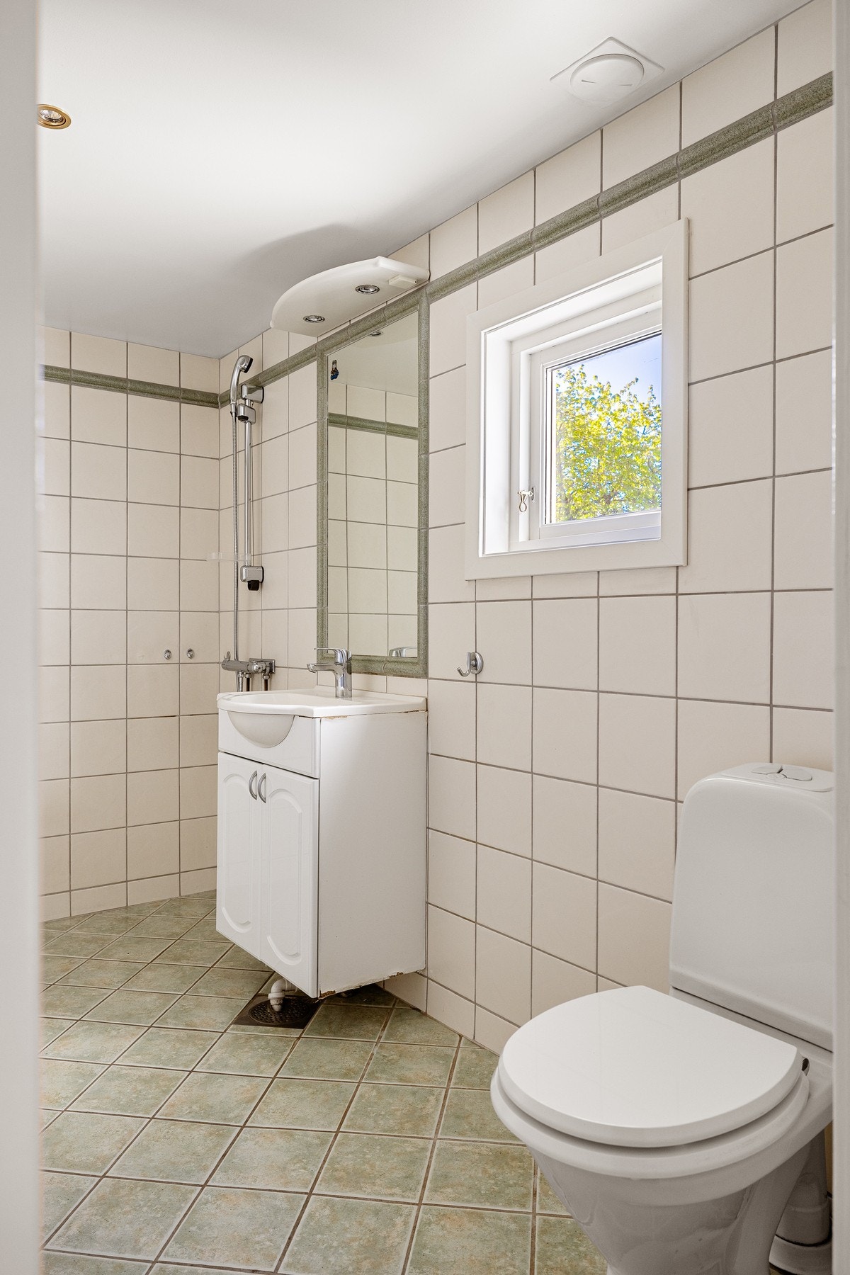 Baderommet ble i følge tidligere eier pusset opp i 2001. Det er fliser på gulv og vegger, downlights i himlingen og et lite vindu som slipper inn naturlig lys. Galleribilde