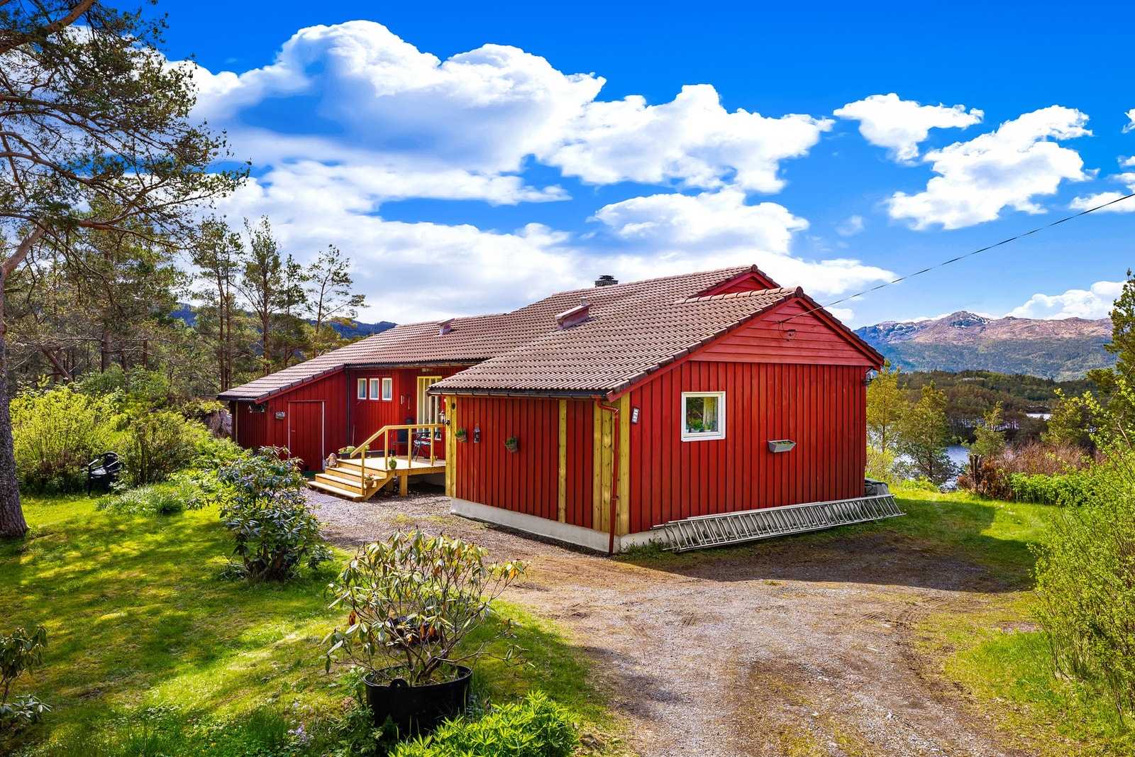 Uteområdet er pent opparbeidet med gruset innkjørsel, gressplen og diverse beplantning. Galleribilde