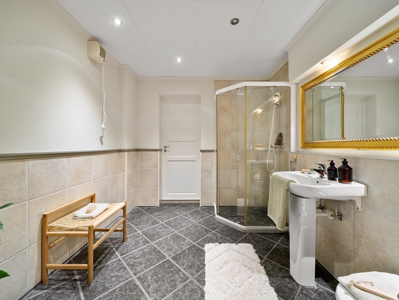 Badet er innredet med vegghengt toalett, servant og dusj. Galleribilde