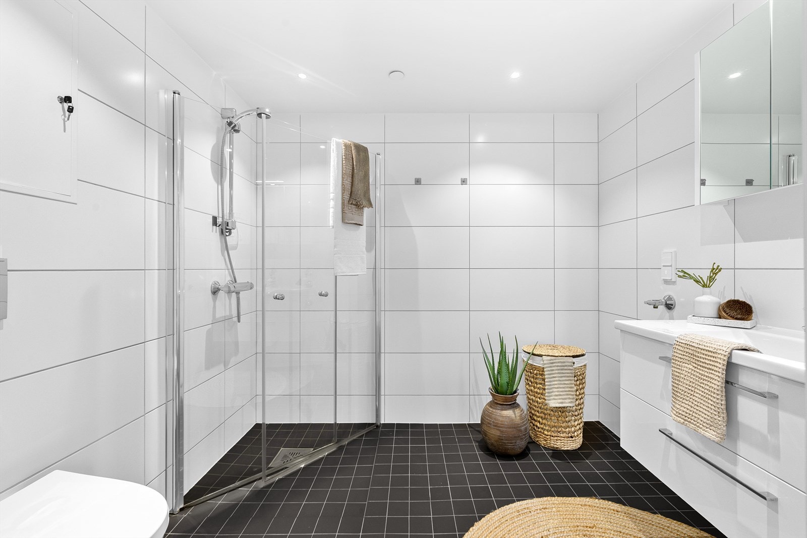 Det 5 m² store badet fremstår som innbydende med helflisede overflater og behagelig gulvvarme. Galleribilde