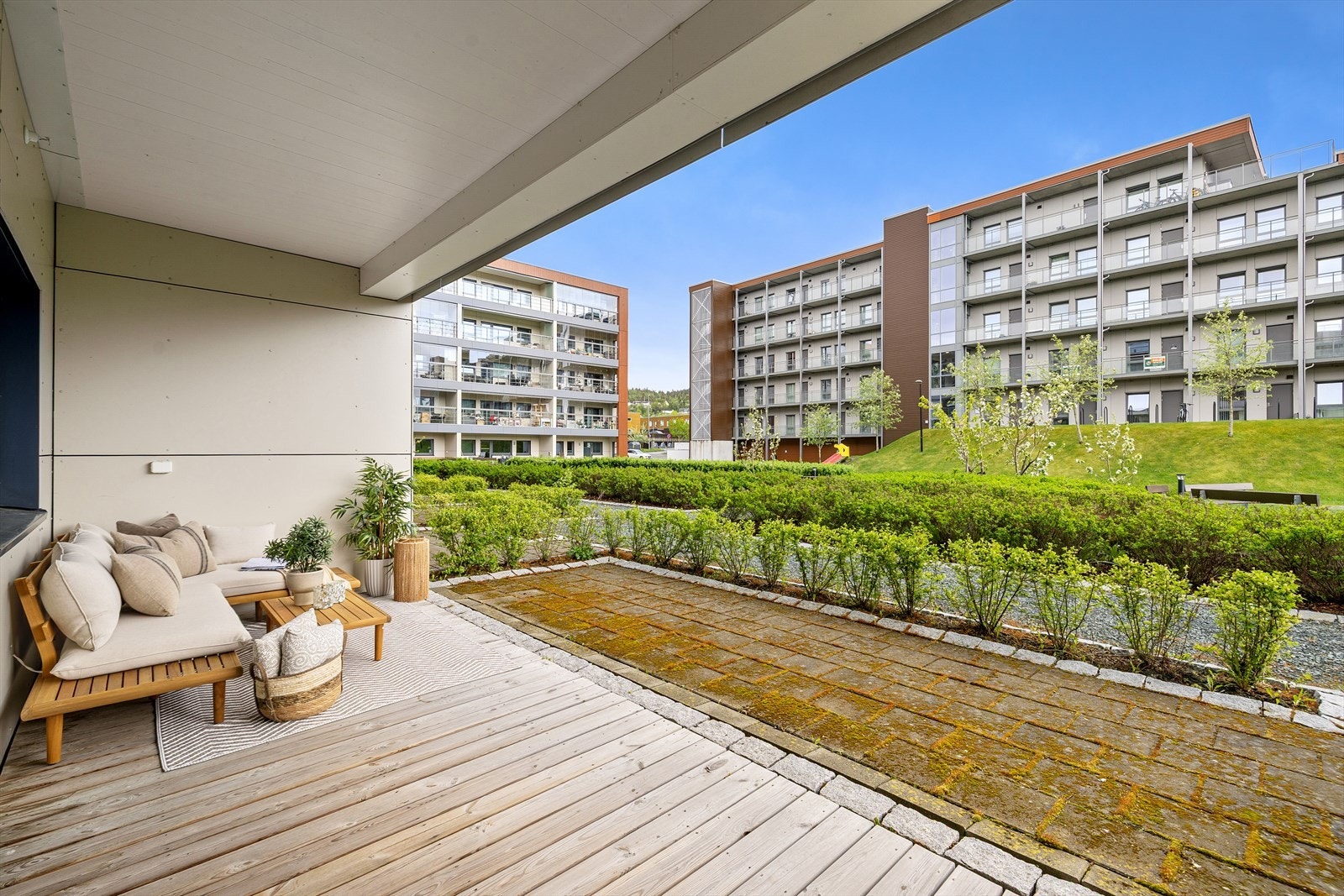 Terrassen oppleves som åpen og lun, og vender inn mot sameiets fellesareal. Fra terrassen har man direkte adgang til steinlagt uteplass som omkranses av en grønn hekk på sommerstid. Dette har nåværende eier satt stor pris på. Galleribilde