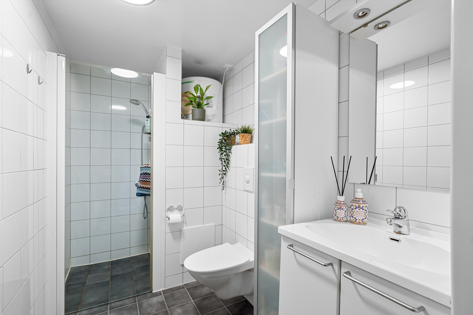 Badet er innredet med servant nedfelt i en praktisk skapseksjon, som gir gode oppbevaringsmuligheter og en ryddig helhet. Galleribilde