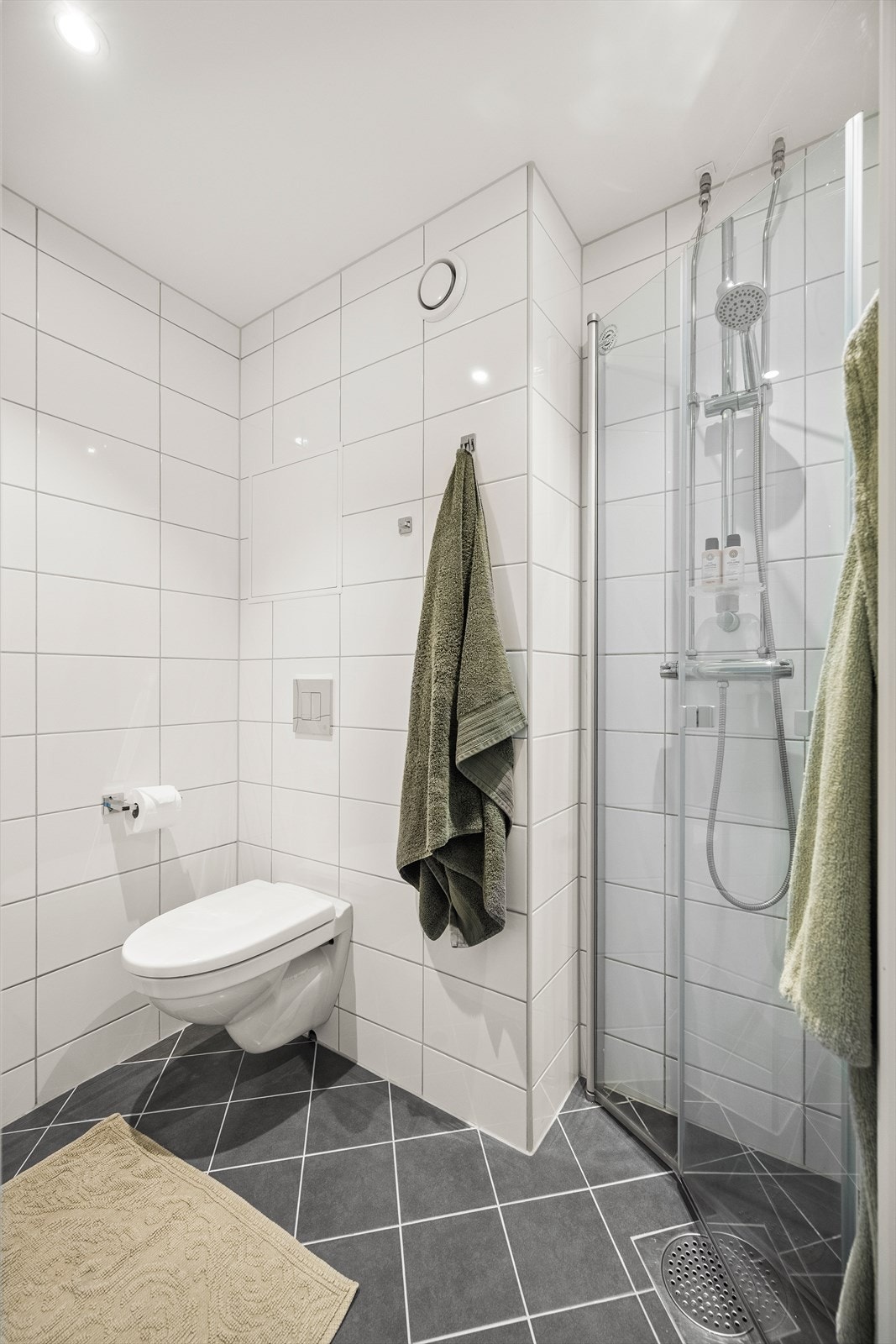 Videre har badet dusjhjørne med svingbare glassdører. Galleribilde