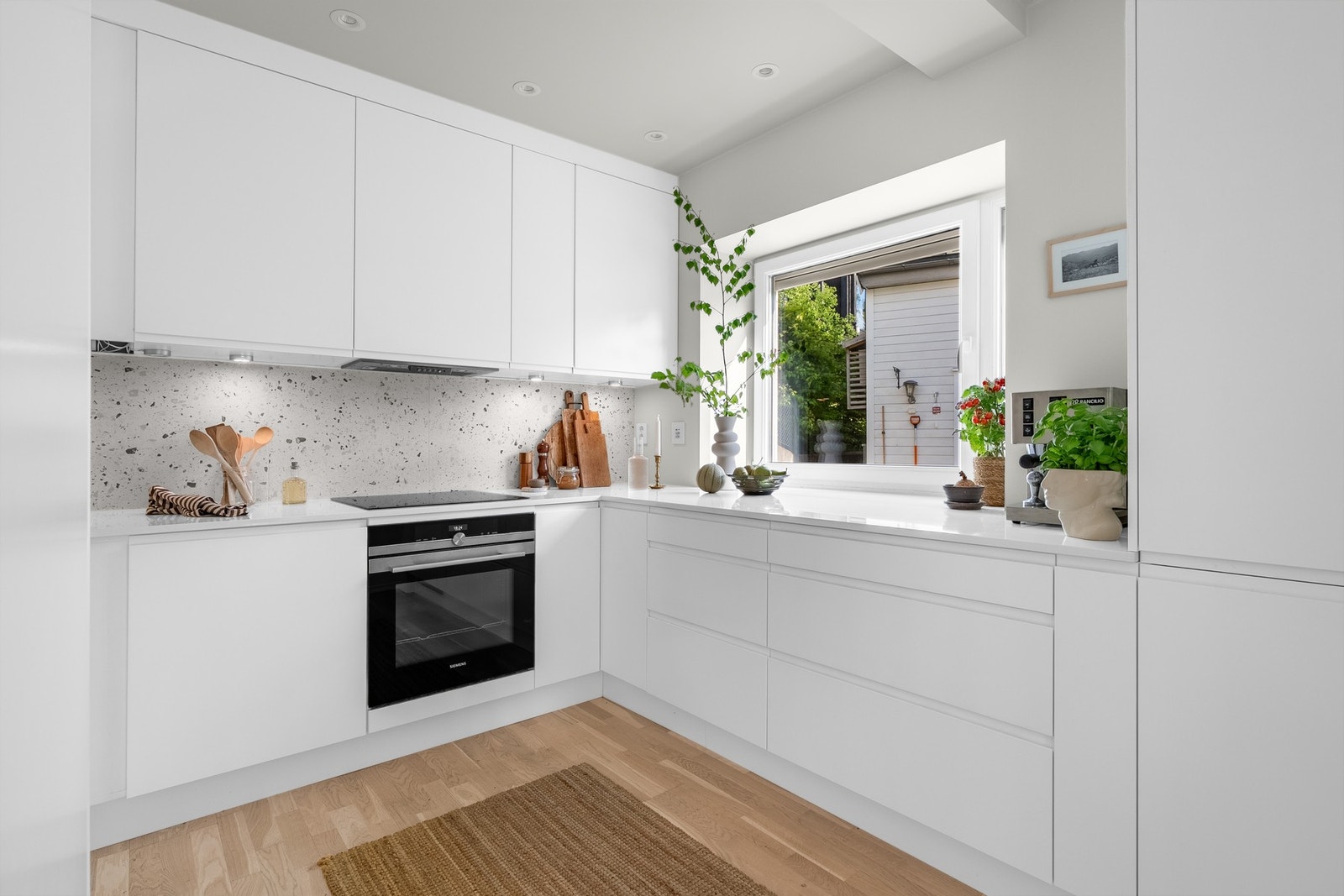 Stilrent kjøkken oppgradert i 2022 med ny Quartz benkeplate i 20mm samt flott flisfelt under overskap i "Terrasso" stil Galleribilde
