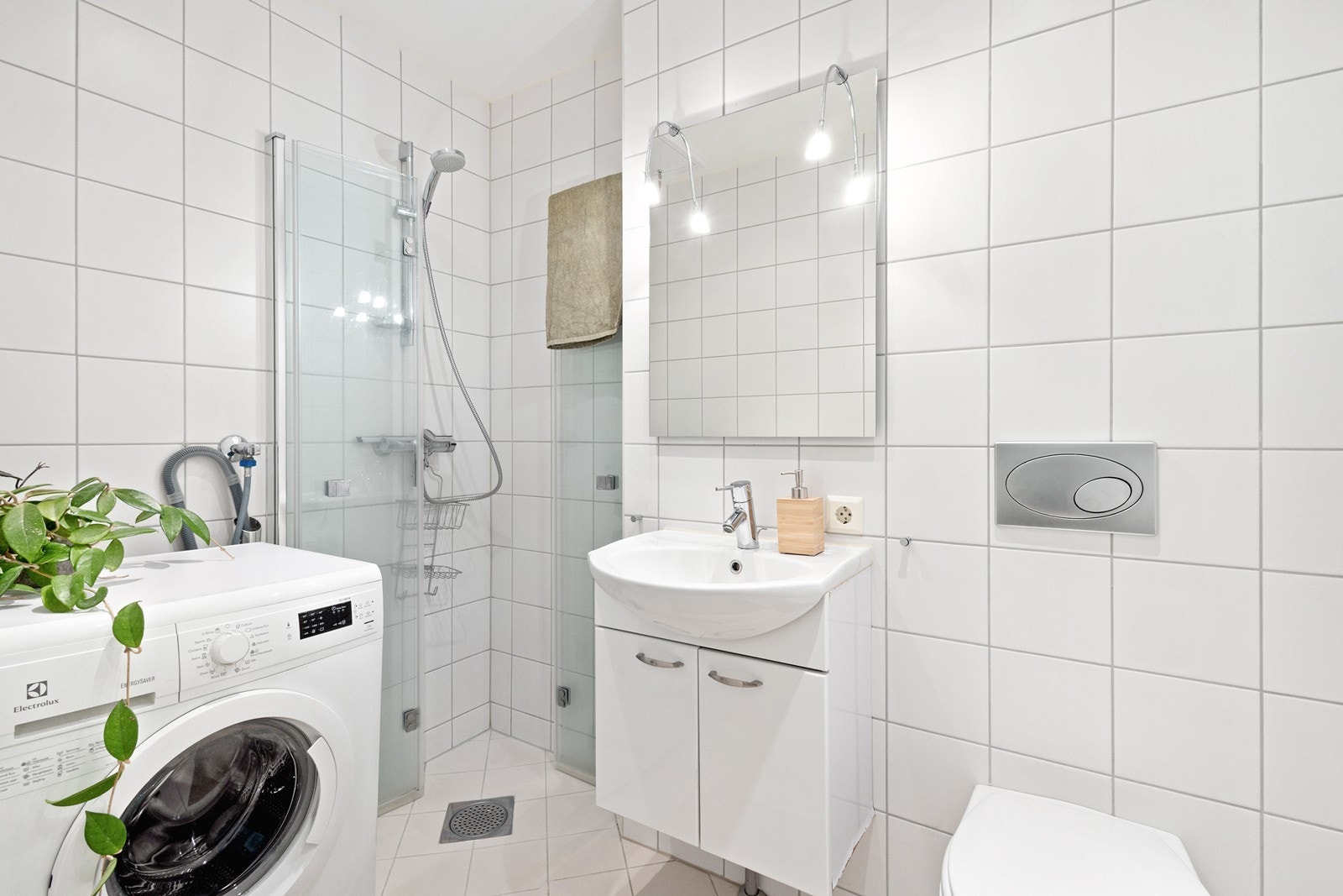Lyst og tidløst bad fra 2010 med opplegg for vaskemaskin. Galleribilde