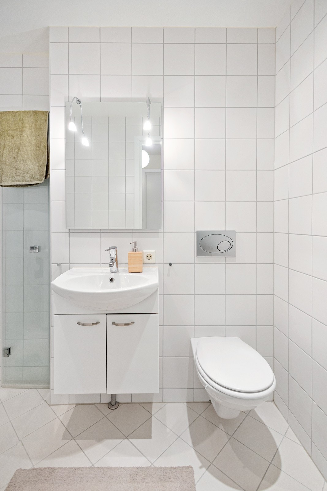 Veggmontert toalett og skapinnredning med heldekkende servant. Det er balansert ventilasjon med avtrekk via ventil i tak. Galleribilde