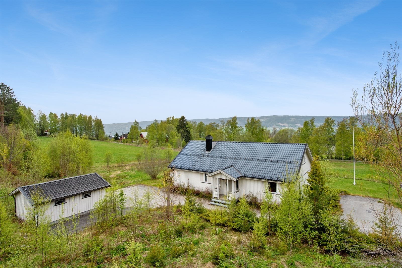Eiendommen består av en enebolig og en frittstående garasje, omkranset av en stor tomt. Galleribilde