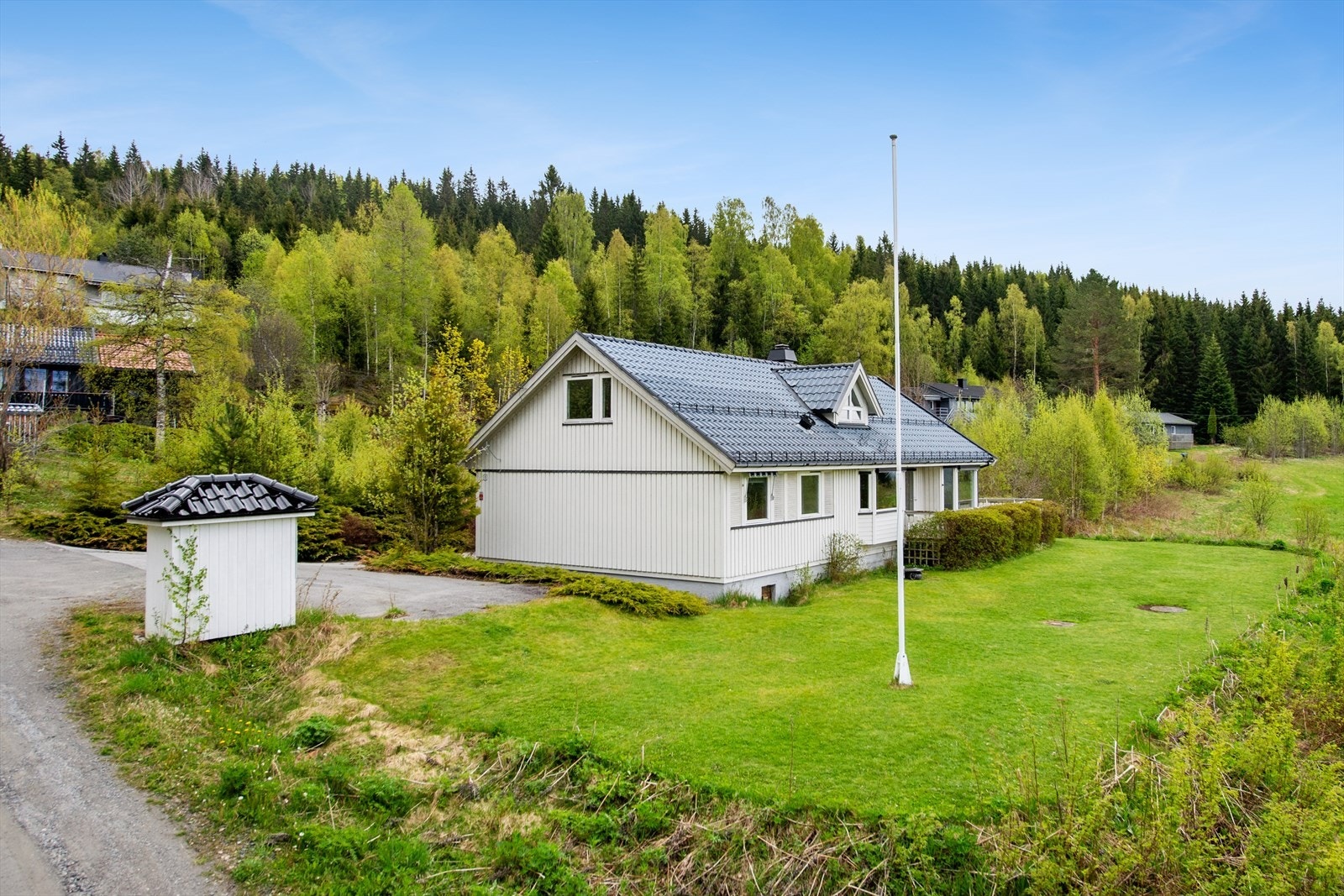 Stor, opparbeidet tomt med plen og diverse beplantning som gir god plass for lek og rekreasjon. Galleribilde