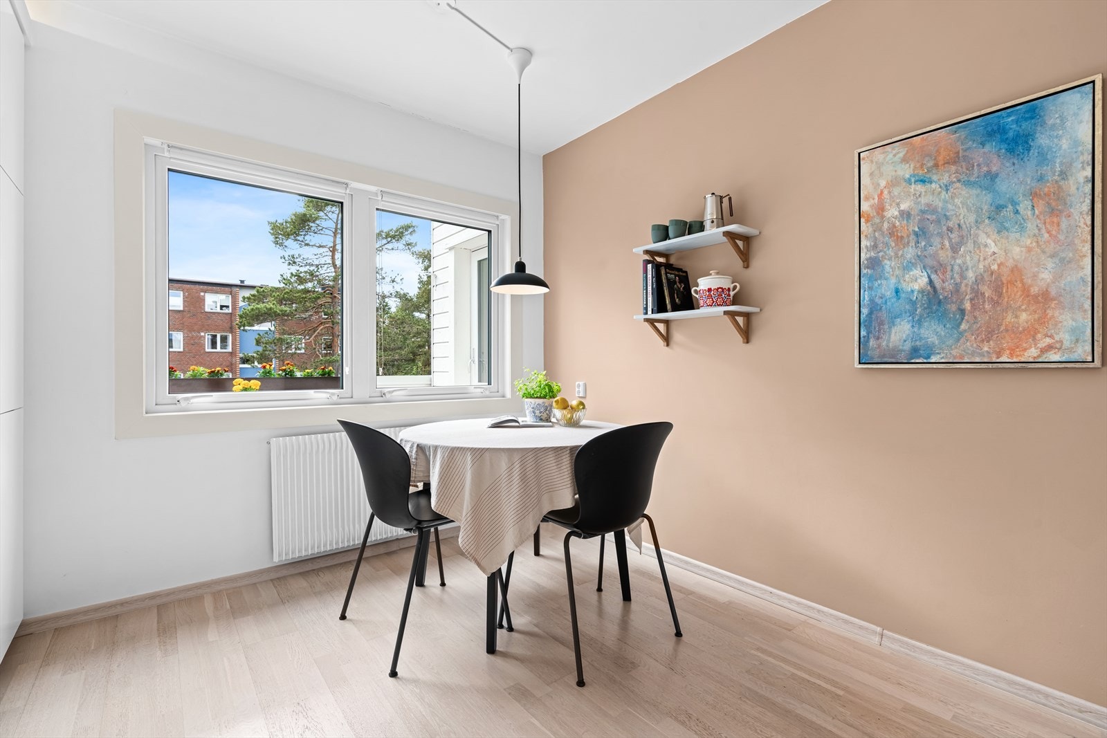 Det er god plass til spisebord ved vinduet, og vinduet gir utsikt mot trærne på eiendommen. Galleribilde