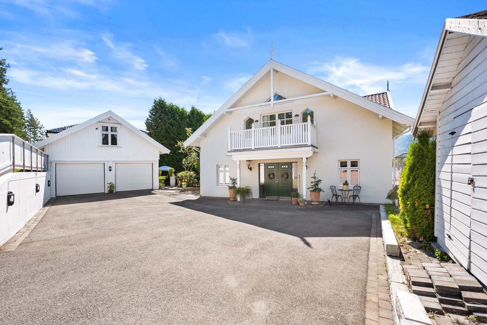 Gode parkeringsmuligheter på egen eiendom, både i gårdsplass, garasje og i carport. Porten til venstre er til garasje og porten til høyre for carport. Galleribilde