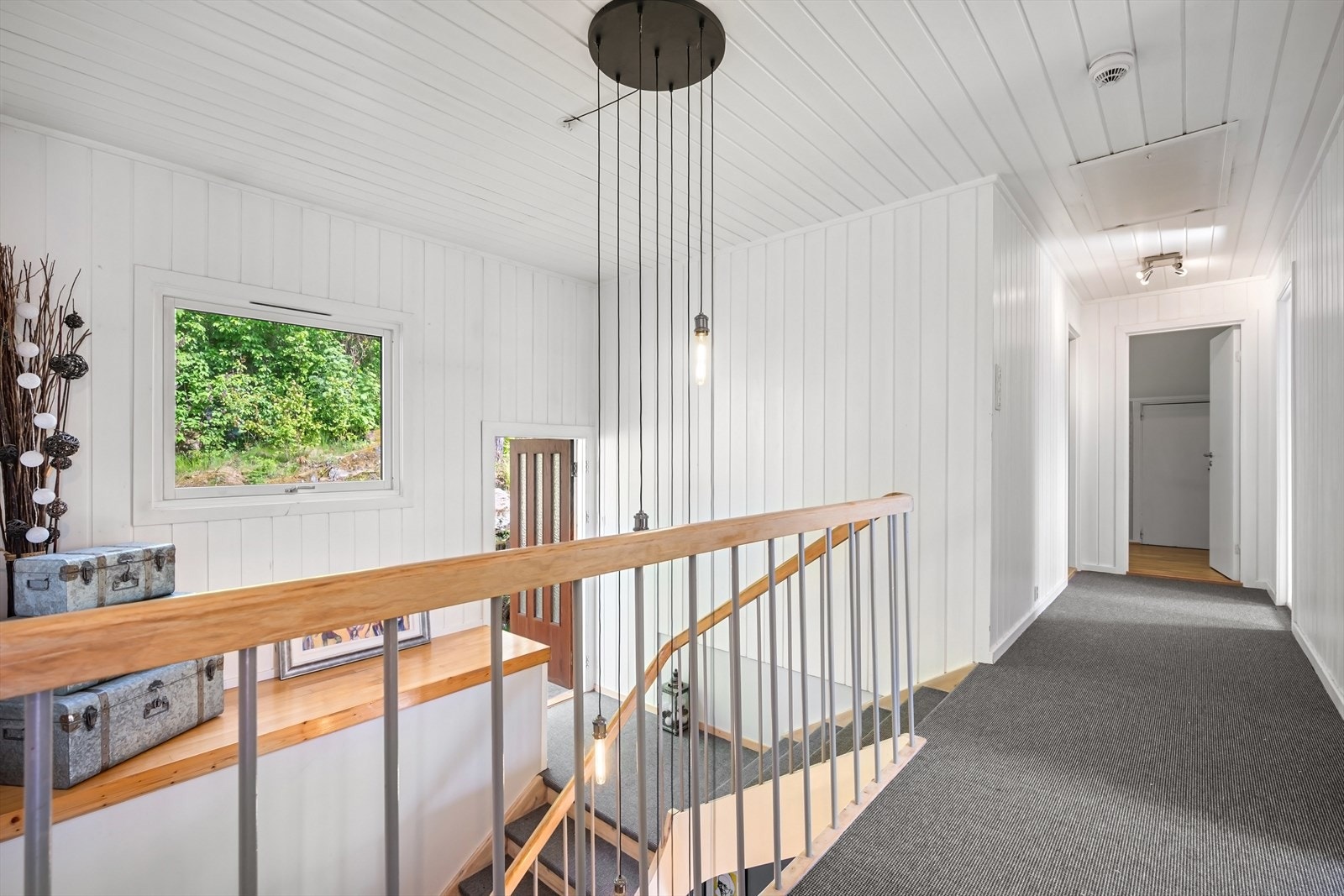 Mellom 1. og 2. etasje har man egen utgang til baksiden av huset og hagen Galleribilde