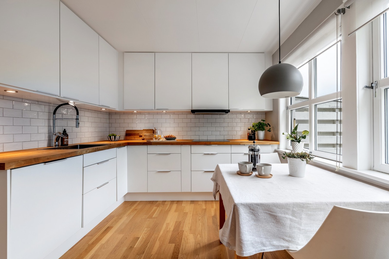 Moderne kjøkkeninnredning fra omkring 2018, med glatte fronter og heltre benkeplater med nedfelt kum. Galleribilde