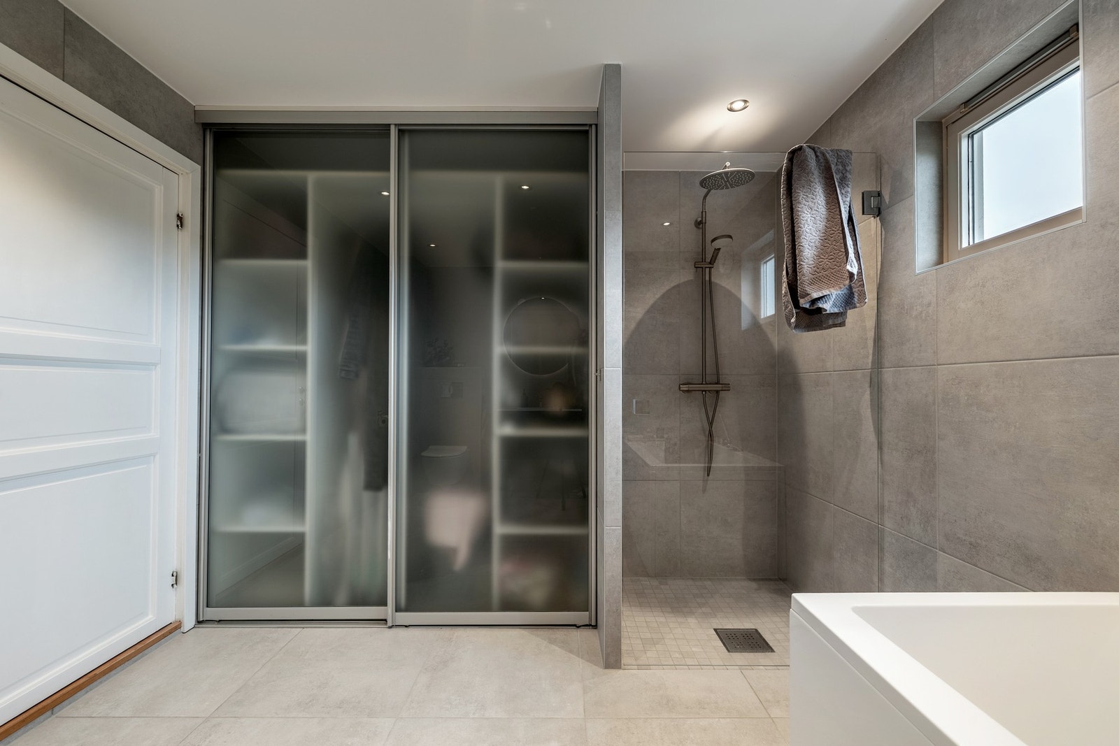 På badet er det hylleinnredning bak skyvedører i frostet glass og opplegg for vaskemaskin. Galleribilde