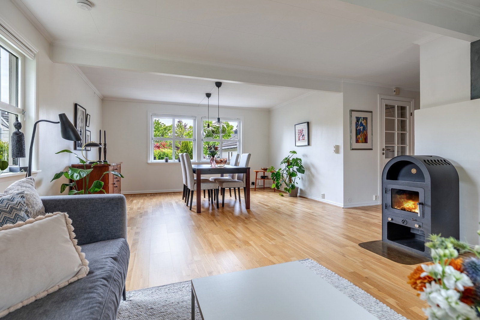 En flott vedovn med flammeinnsyn bidrar til både varme og hygge på kjølige dager. Rommets størrelse gir godt med plass til både en komfortabel TV-lounge og en romslig spisestue, som enkelt kan deles inn i ulike soner. Galleribilde