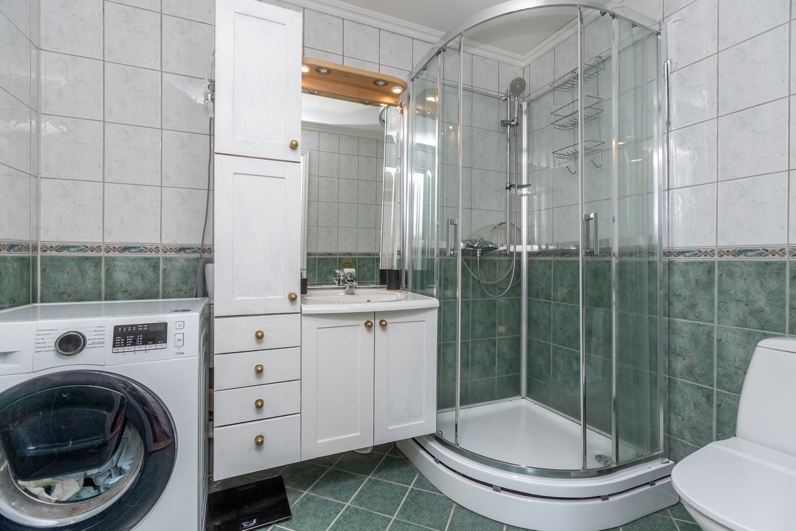 Keramiske fliser på gulv og vegger gir badet et solid og praktisk preg. Galleribilde