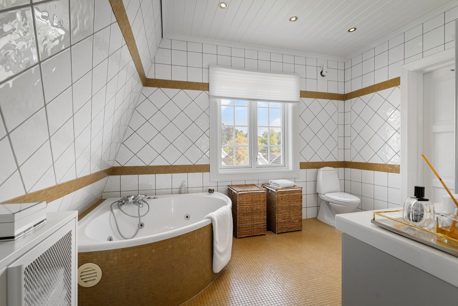 Rommet har innfliset speil, store vindusflater som gir godt naturlig lysinnslipp og dimbare spotter som belysning. Badet er innredet med nyere skuffeinnredning med nedfelt servant, toalett, badekar og dusjhjørne med dusjvegger. Galleribilde