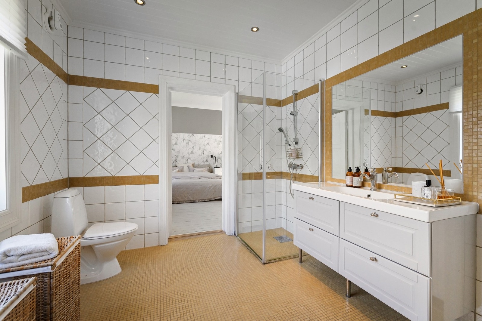 Bad 1 - Badet har flislagte vegger av ulik type, mosaikkfliser på gulv med varmekabler samt malt panel i himling. Galleribilde