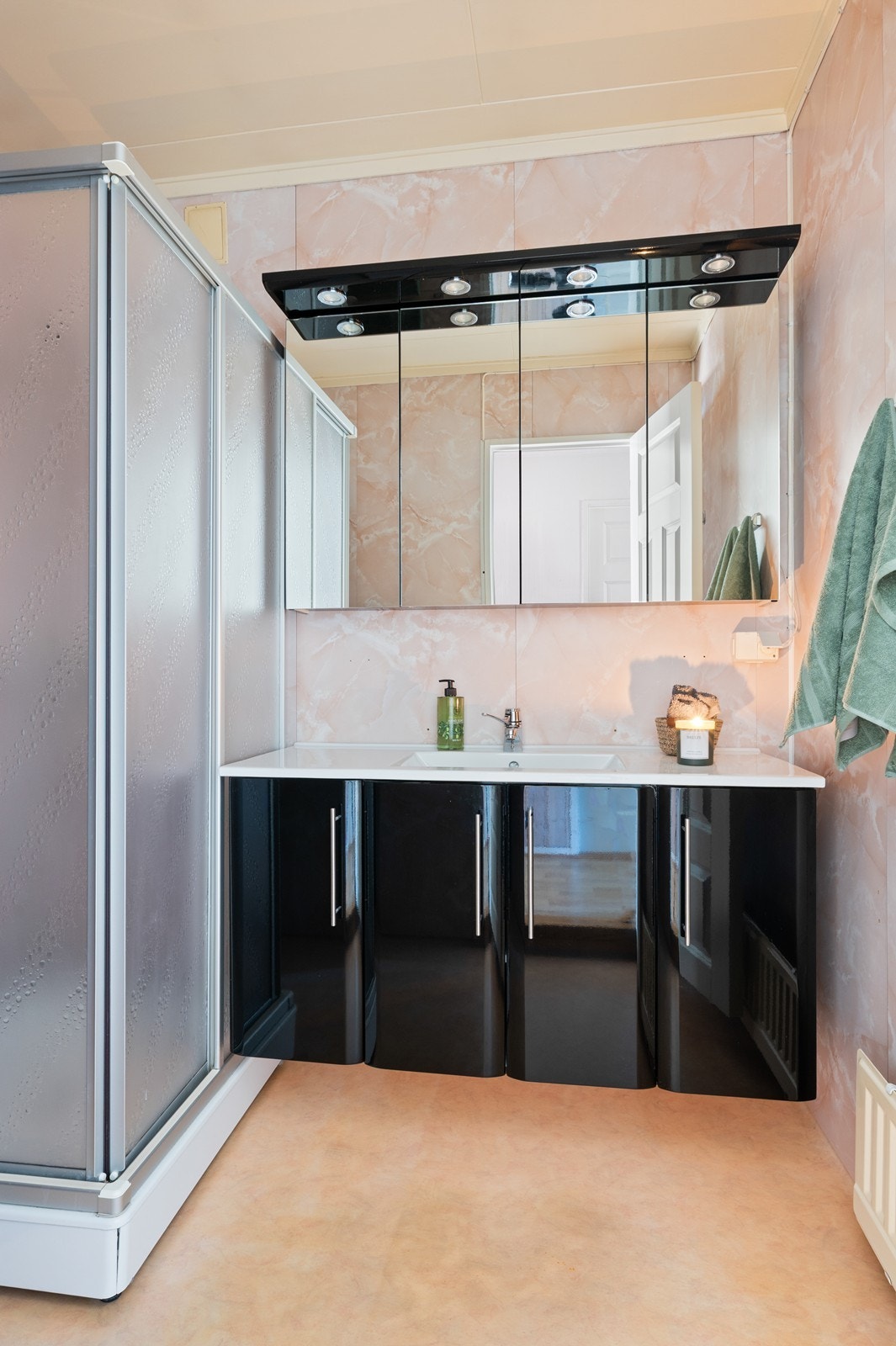 Badet er innredet med servantinnredning med speilskap over og dusjkabinett. Galleribilde