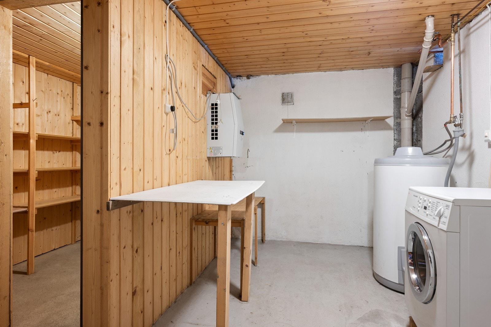 I kjelleren er det et enkelt vaskerom med installasjoner som varmtvannstank på ca. 200 liter, og opplegg for vaskemaskin. I tilknytning til dette ligger et eget kjølerom. Galleribilde