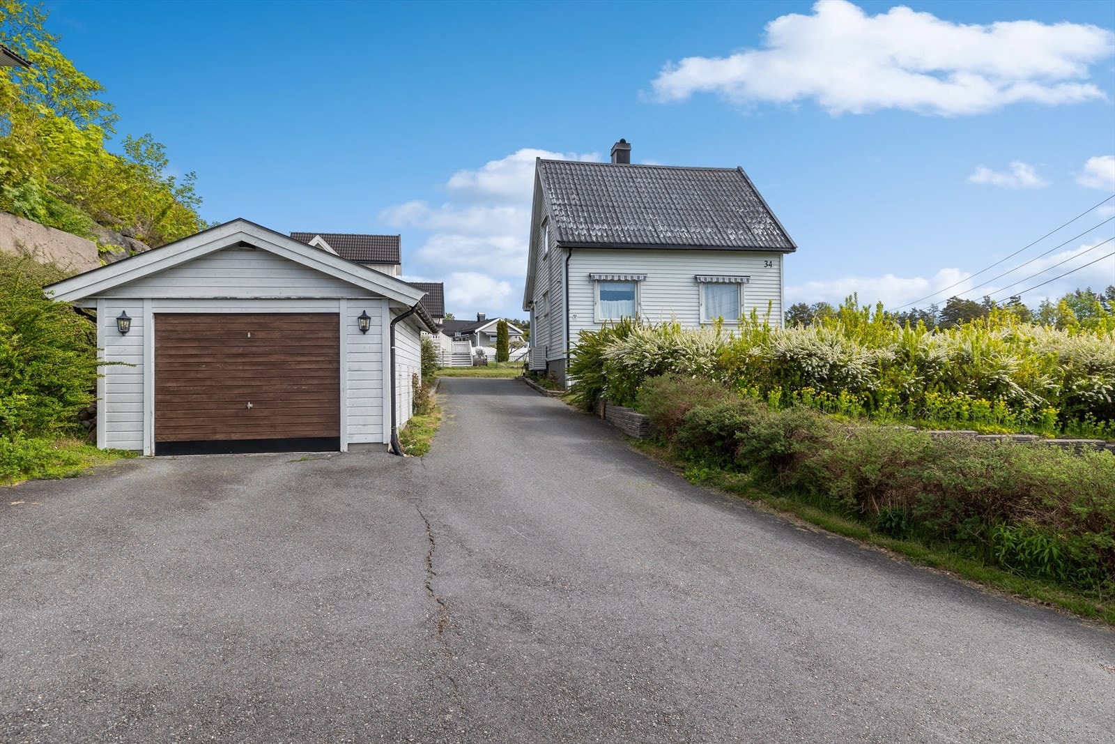 Uteområdet er pent opparbeidet med asfaltert gårdsplass som gir gode parkeringsmuligheter, samt plenarealer og variert beplantning som skaper en hyggelig og grønn ramme rundt boligen Galleribilde