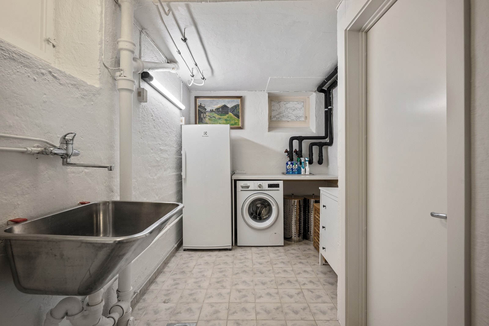 Eget vaskerom/vaskekjeller gir en praktisk og tilbaketrukket løsning for klesvask, med opplegg for vaskemaskin og skyllekum. Galleribilde