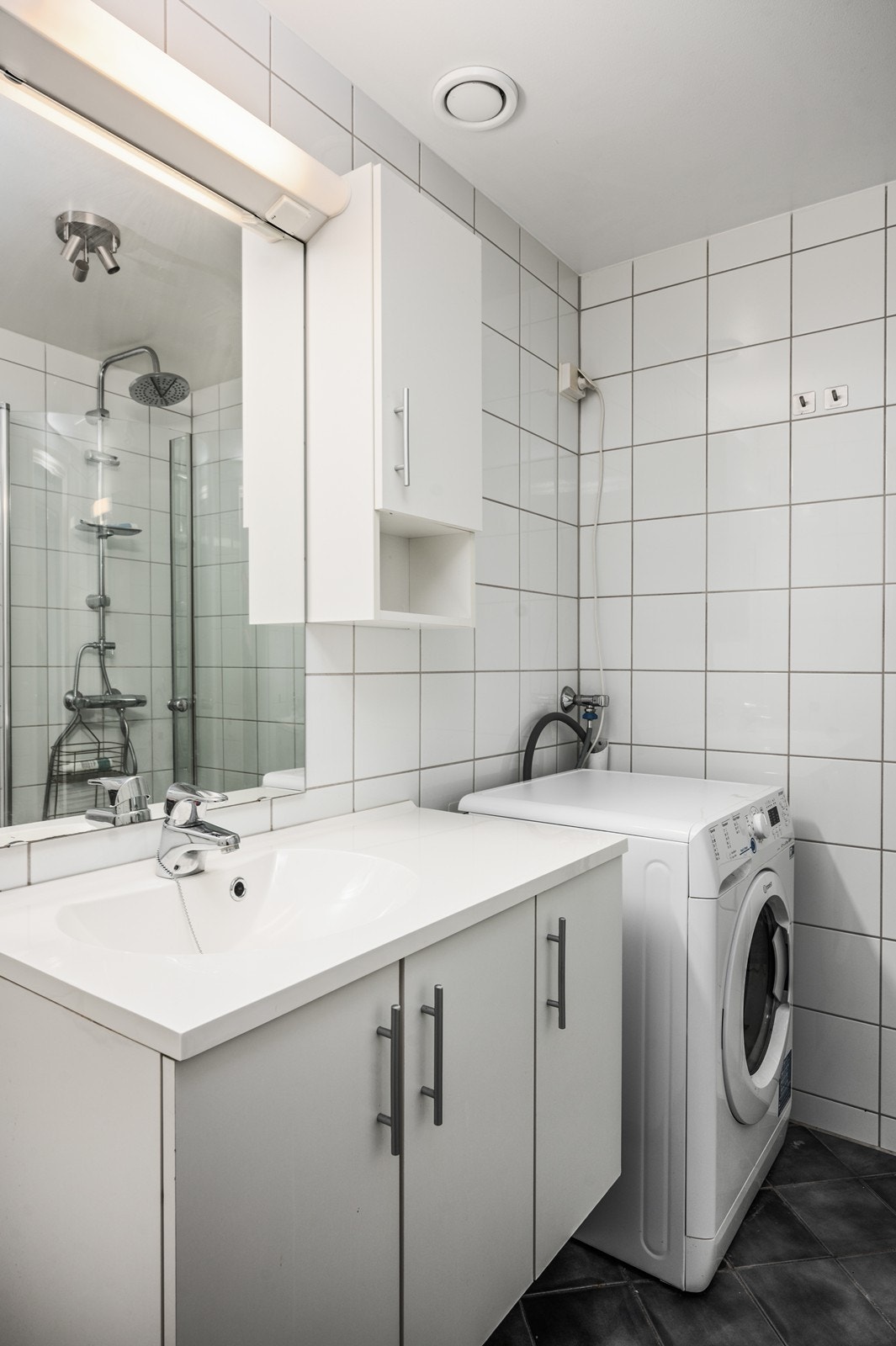 Badet har servantinnredning med praktisk oppbevaring, samt opplegg for vaskemaskin Galleribilde