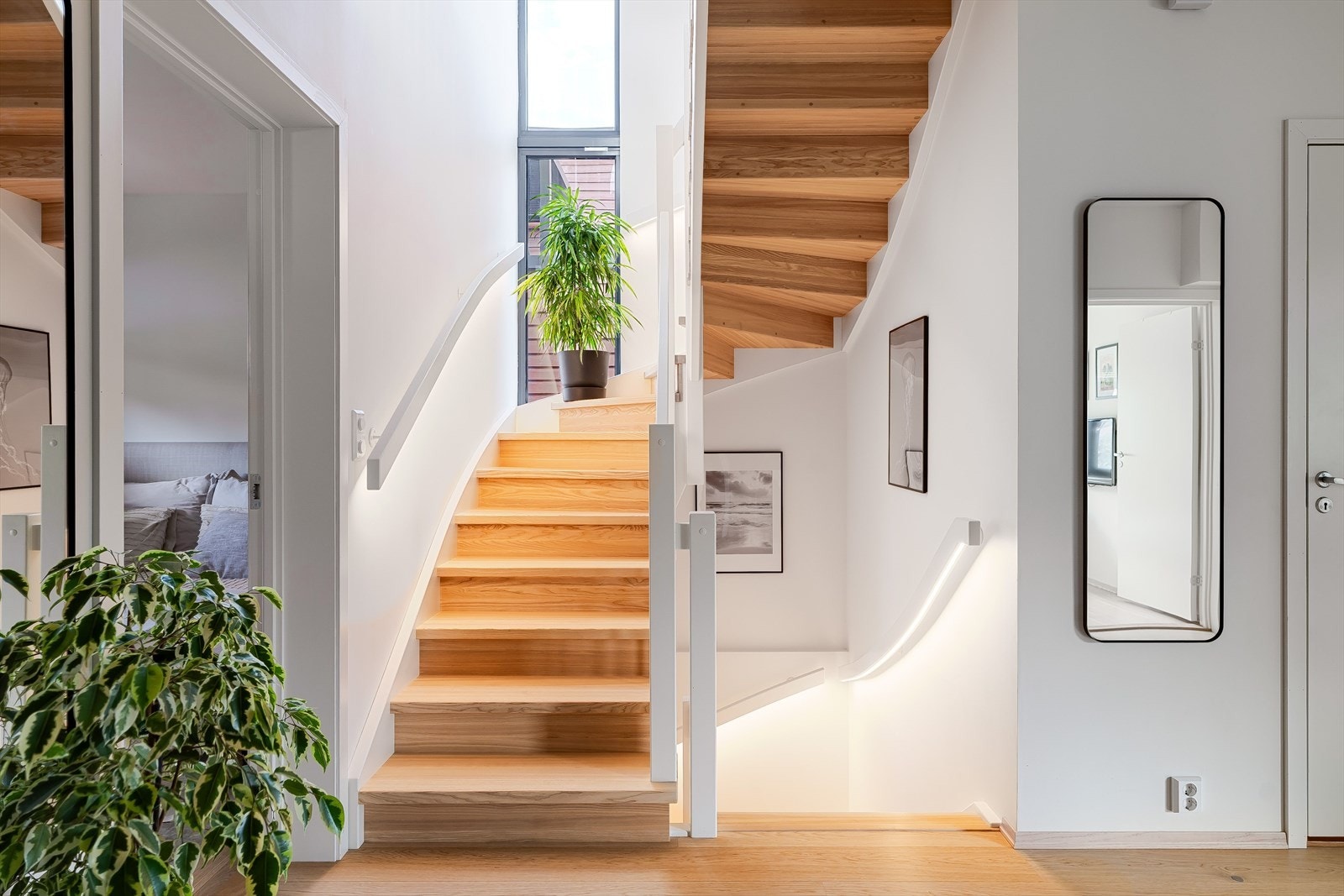 Lyst trapperom med store vindusflater og moderne LED-belysning i håndløperne. Galleribilde