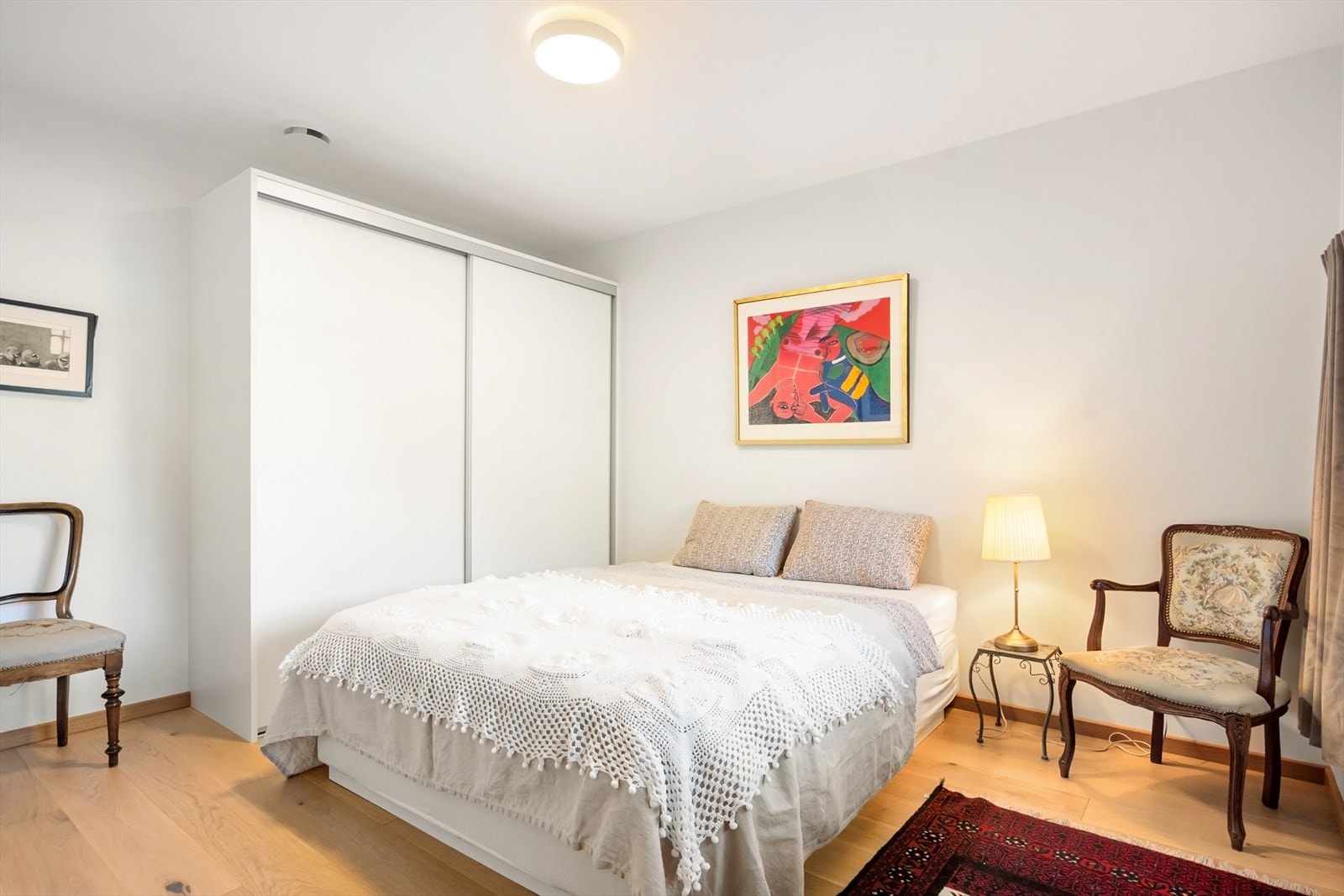 En stor skyvedørsgarderobe med hvite fronter gir rikelig med oppbevaringsplass. Galleribilde