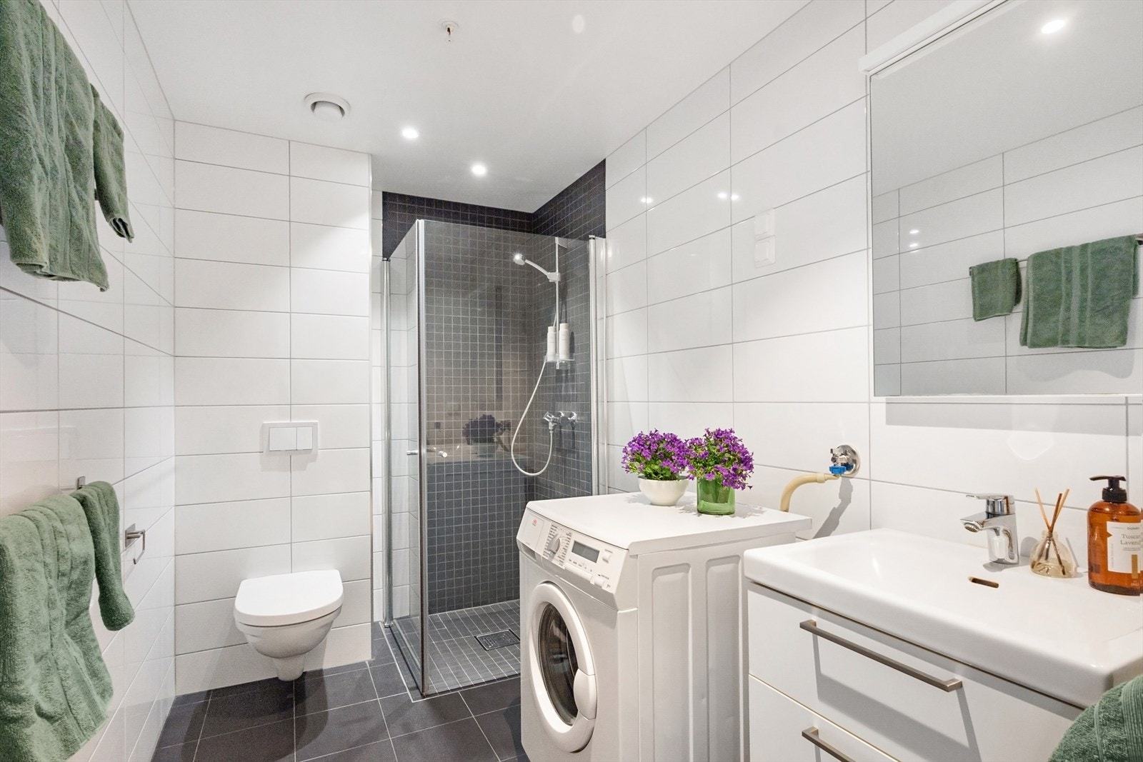 Downlights i tak gir god belysning, og servantskap med glatte, høyglansede fronter bidrar til et moderne uttrykk. Badet er av god størrelse og med opplegg for vaskemaskin. Galleribilde