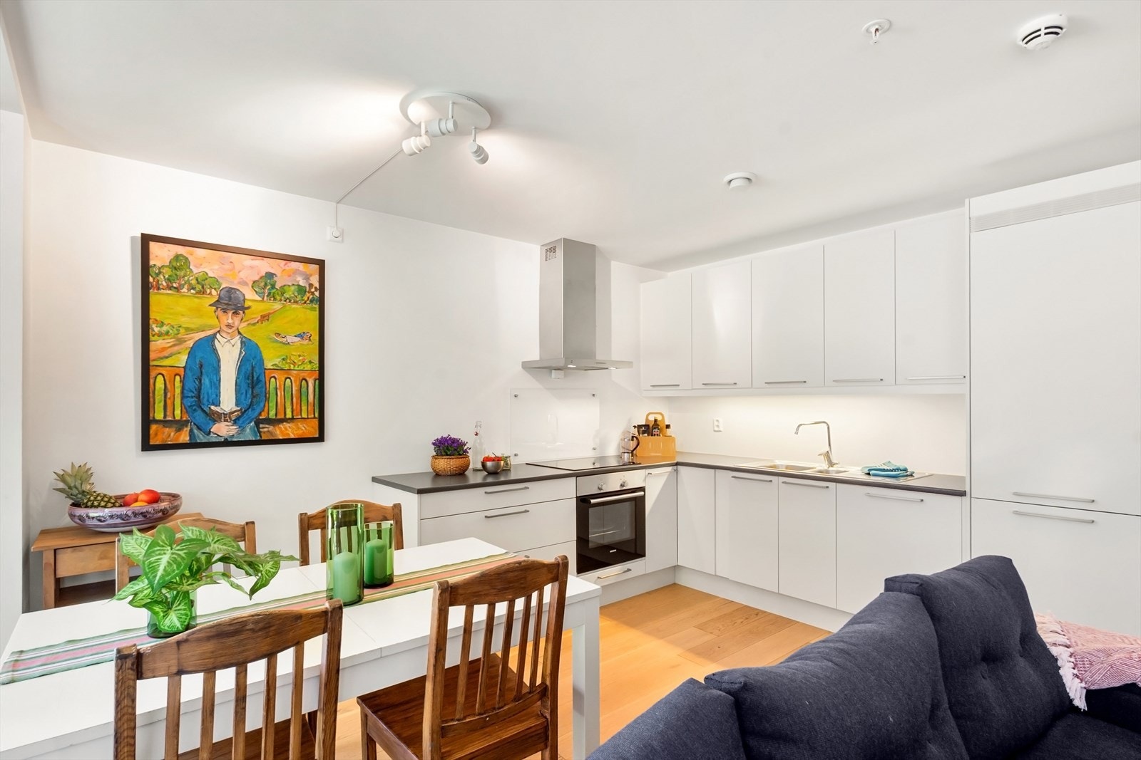 Innredningen har hvite fronter og laminat benkeplate med planlimt kum i rustfritt stål. Galleribilde