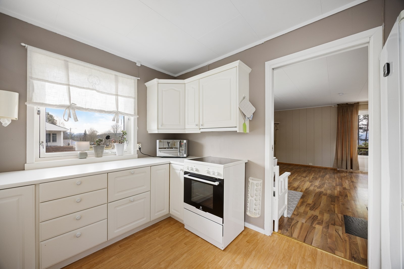 Kjøkkenet har innredning av eldre dato med profilerte fronter og laminat benkeplate. Det er installert oppvaskmaskin, frittstående komfyr og ventilator med avtrekk ut. Galleribilde