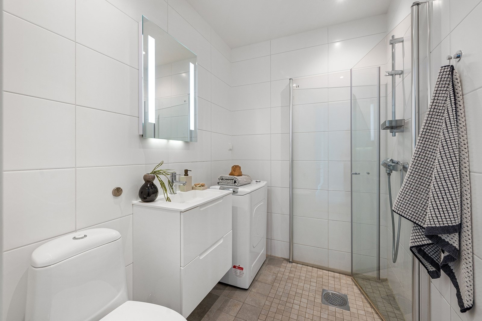 Badet fremstår moderne og delikat med flislagte overflater fra 2016. Innredning fra Scala Bad. Det er varmekabler i gulv. Galleribilde