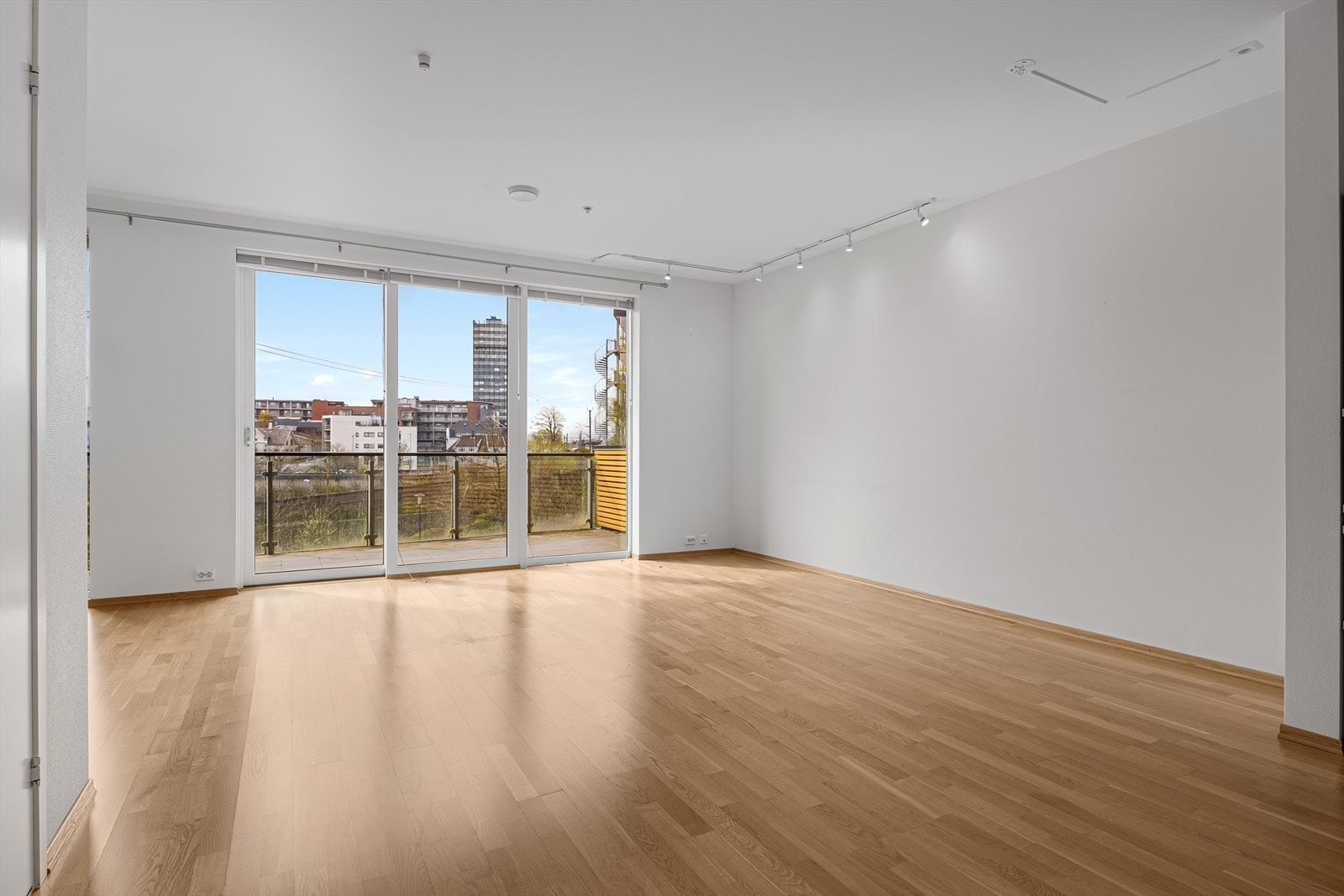 Utsikt fra stuen mot balkongen og fellesarealene utenfor. Galleribilde
