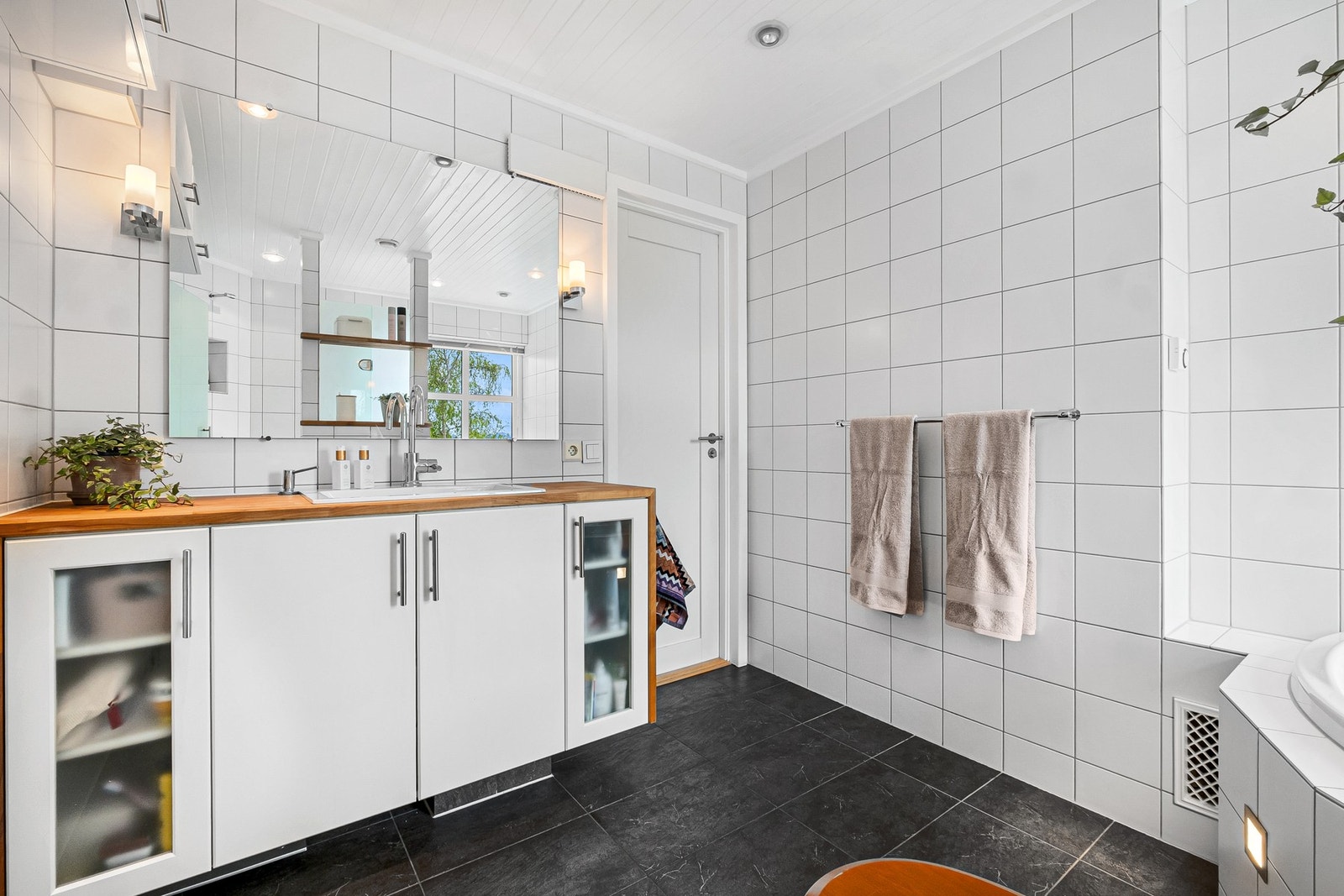 Flislagt bad med gulvvarme. Innredning med nedfelt servant, vegghengt WC, stort badekar og dusjnisje. Galleribilde