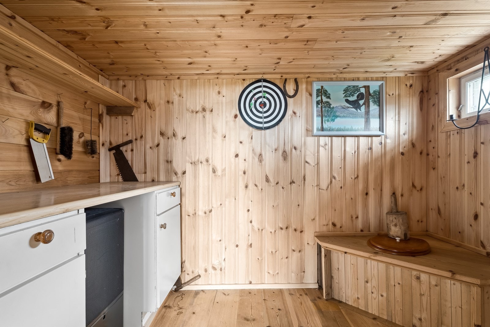Boden i annekset har panel på veggene og tregulv. Rommet er innredet med enkel innredning med benkeplate, vegghengt hylle og utedo. Galleribilde