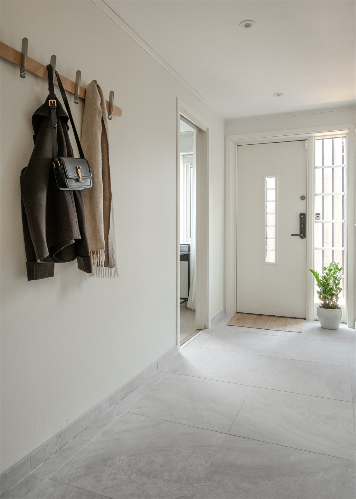 Entréen har flislagt gulv, malte vegger og nedsenket himling med integrerte downlights. Galleribilde