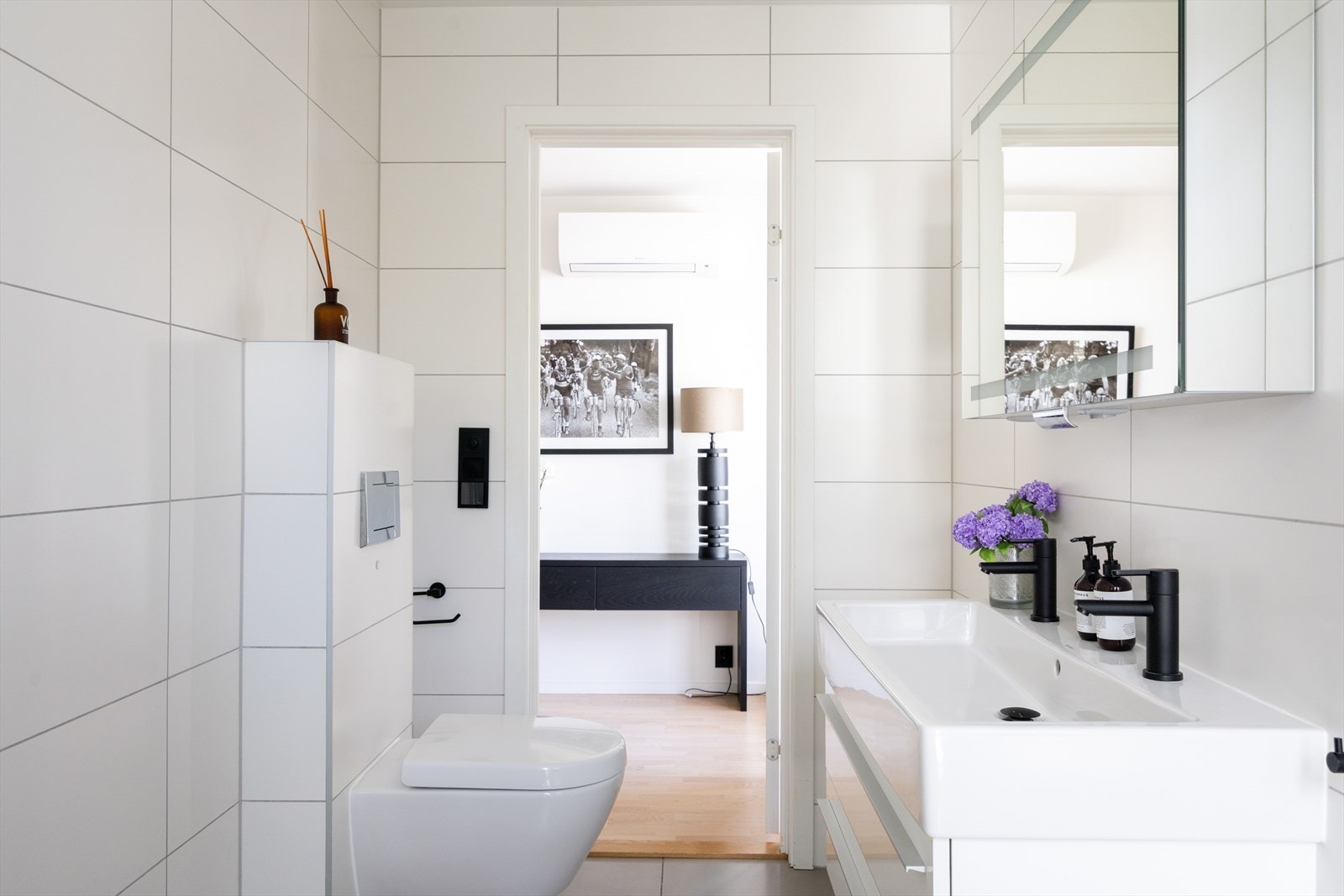 Badet er utstyrt med vegghengt toalett, innmurt badekar med dusjløsning og glassvegg, samt servantinnredning med skuffer, speilskap og belysning. Galleribilde